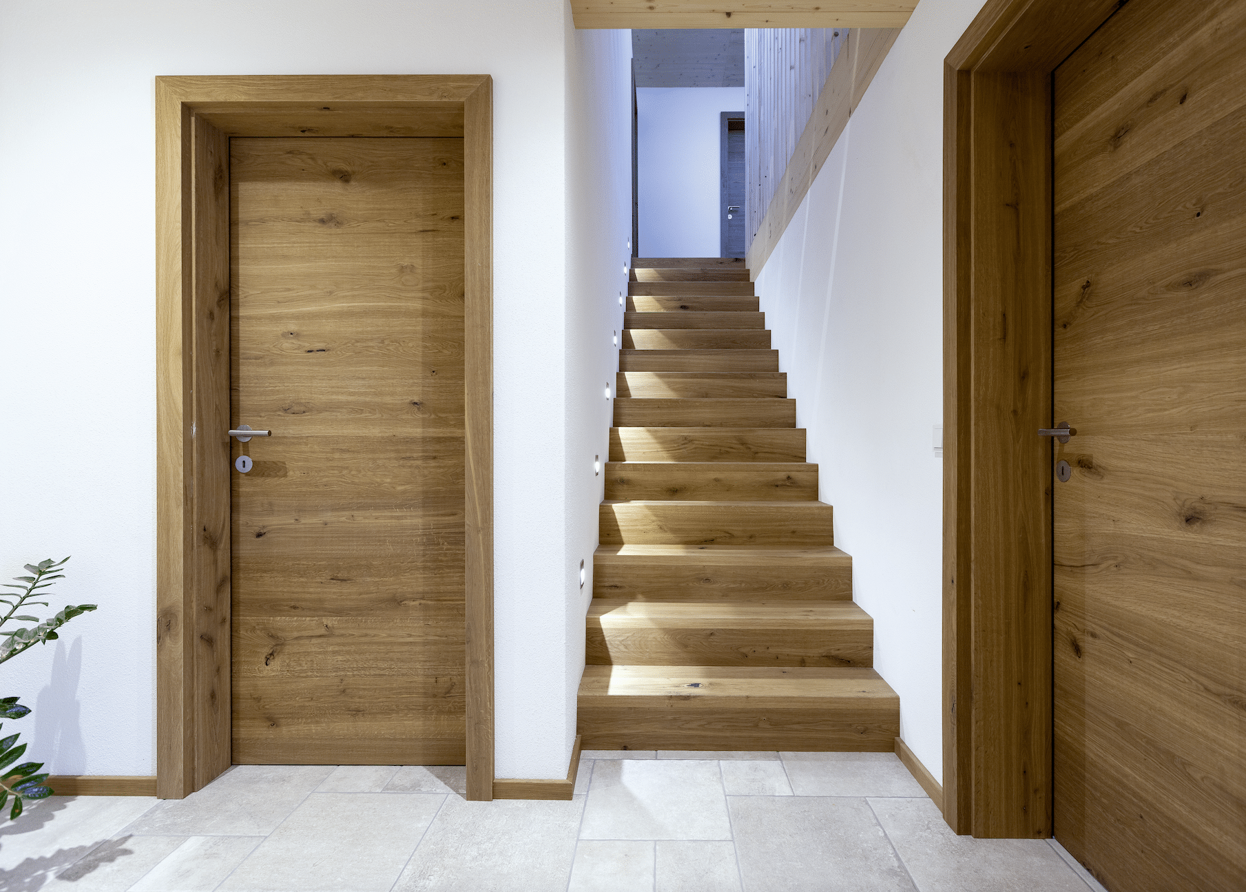 Helles Vorzimmer mit Holztüren und einem Stiegenaufgang aus dem Hause Admonter.