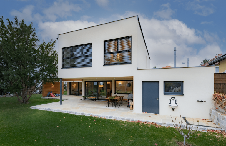 Einfamilienhaus mit Flachdach, überdachter Terrasse und Garage von AL Architekt ZT.