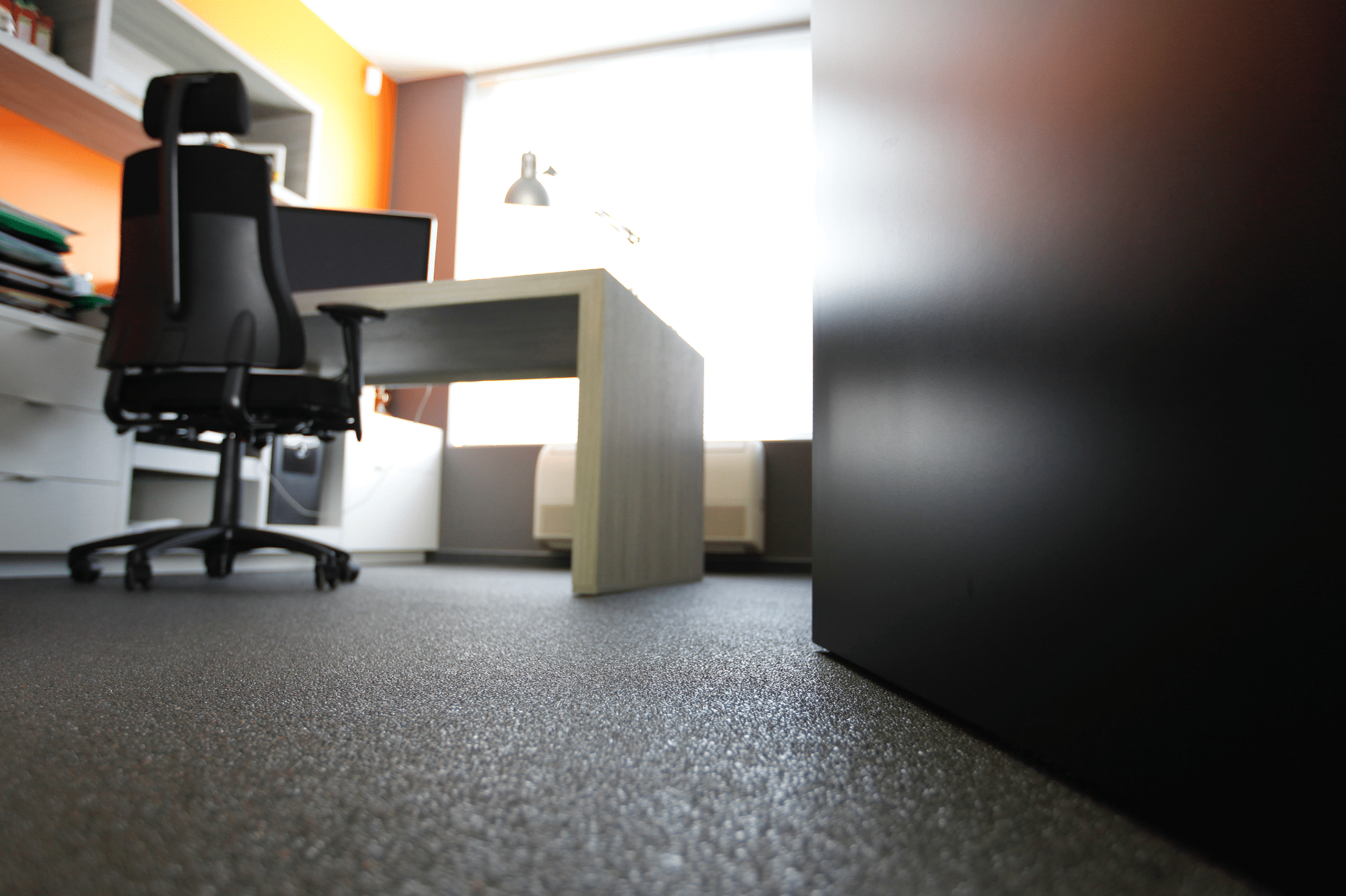 stoneCARPET zeigt einen dunklen Natursteinteppich am Boden einer Büros mit Schreibtisch und mehreren Kommoden.
