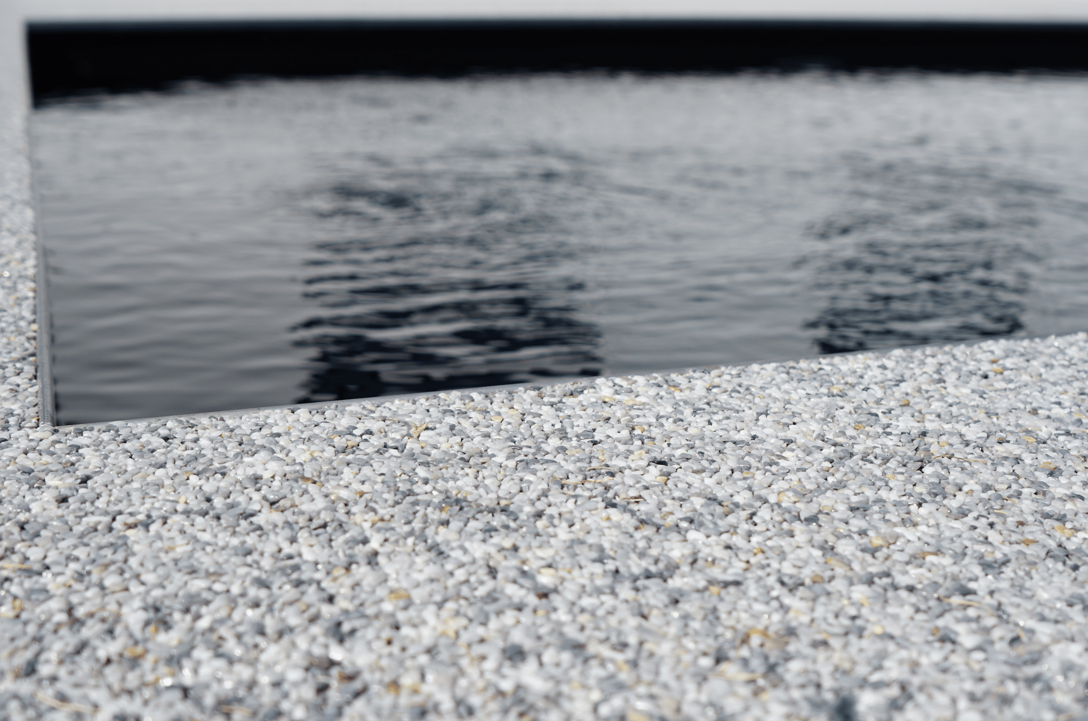 stoneCARPET präsentiert eine edle Poolumrandung, welche aus einem hellen Natursteinteppich geschaffen wurde.