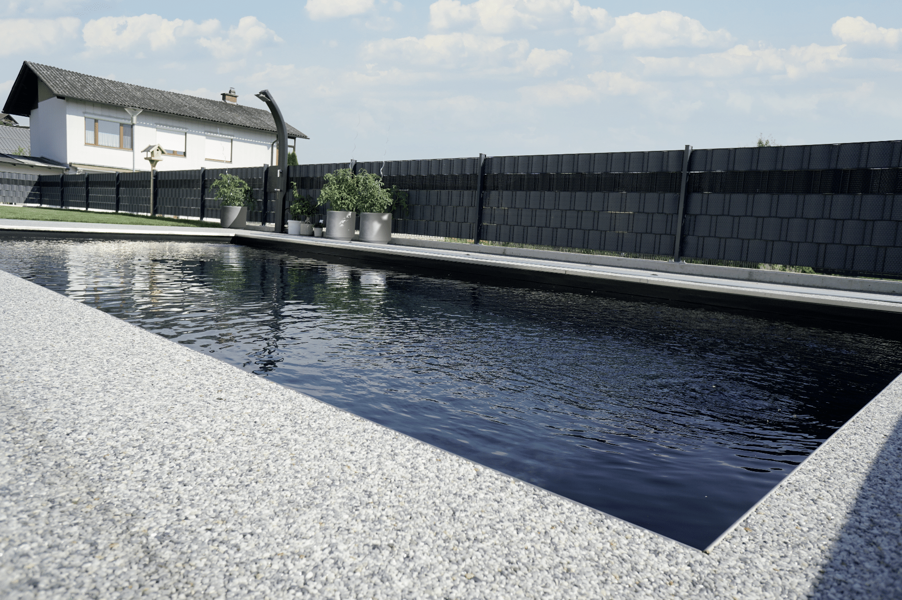 stoneCARPET präsentiert den Kieselteppich auf der Terrasse, welcher rund um den Pool gelegt wurde um das natürliche Gefühl zu wahren.