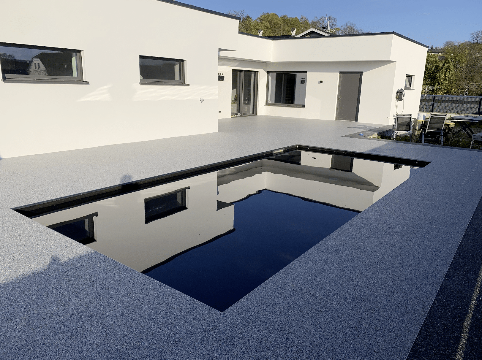 stoneCARPET präsentiert den Kieselteppich auf der Terrasse eines modernen Hauses, welcher rund um den Pool gelegt wurde um das natürliche Gefühl zu wahren.