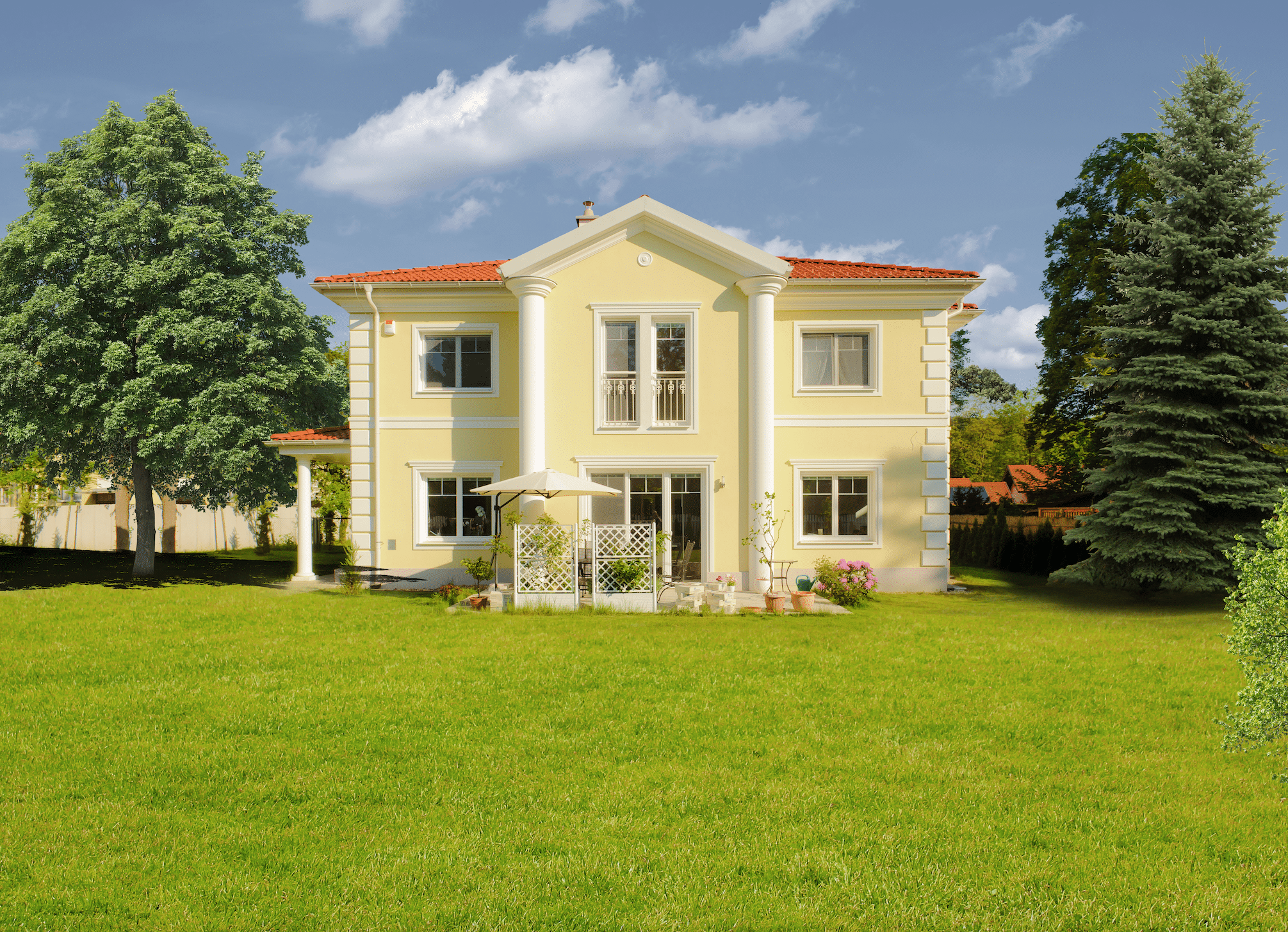 Klasssiche, gelbe Villa mit Säulen und Stuckdesign mit Fassaden-Dämmung von Austrotherm.