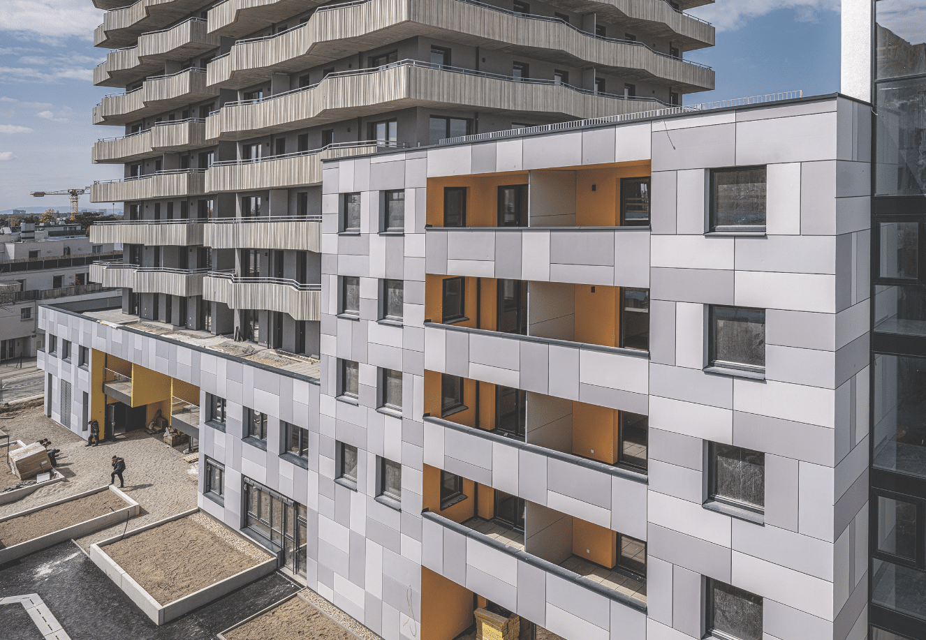 Ein modernes Hochhaus mit vielen Fenstern und Balkonen bei dem Dämmmaterial von Austrotherm verwendet wurde.