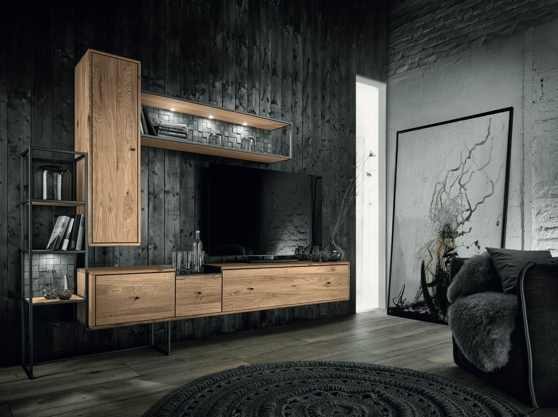 BÖHM MÖEL zeigt ein sehr dunkles Wohnzimmer mit mystischem Bild, einer Holz-Wohnwand mit einem Fernseher darauf und ein paar Büchern.