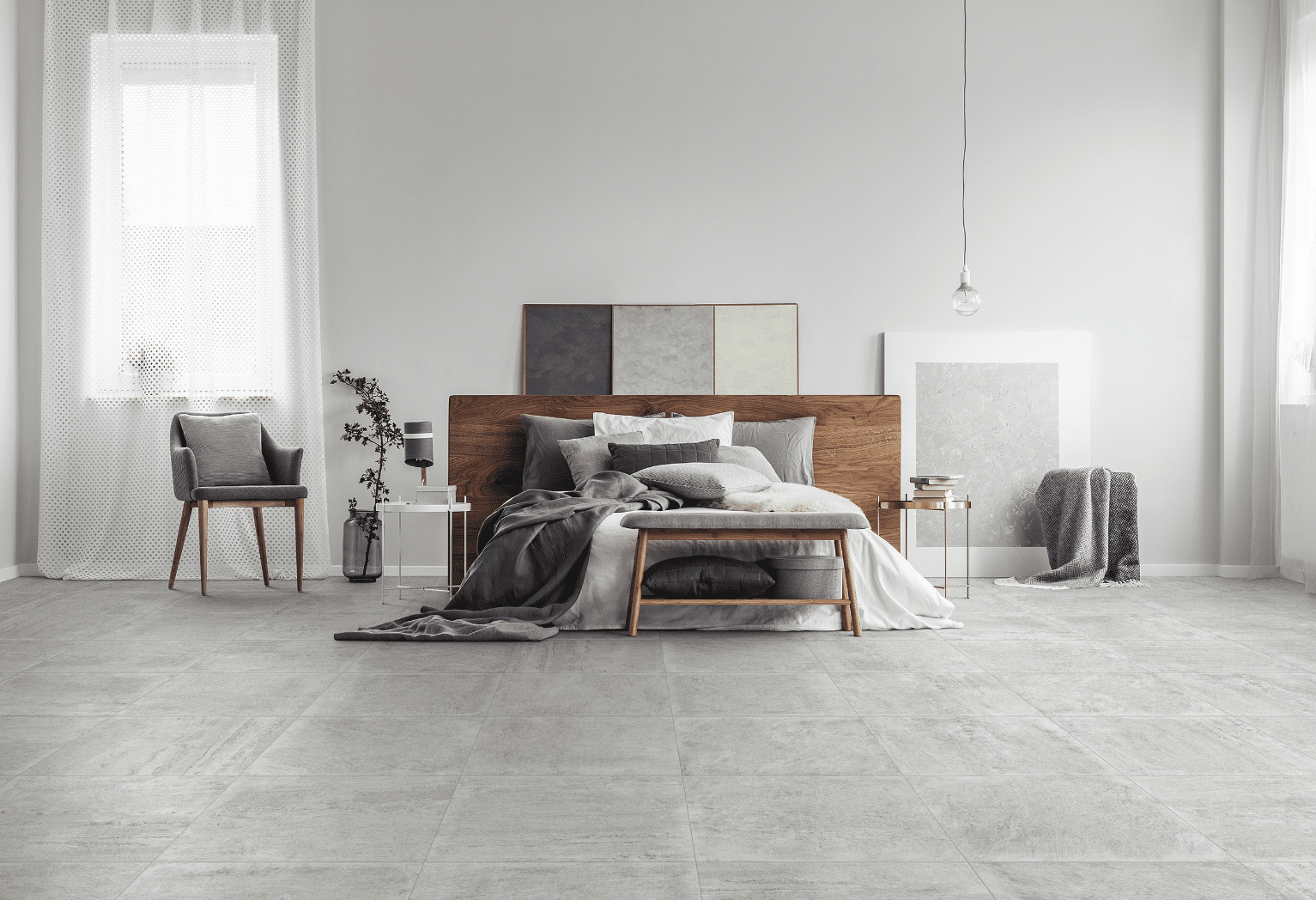 C. Bergmann zeigt ein grau gefliestes Schlafzimmer mit einem Doppelbett aus Holz , grauem und weissen Bezug vor einer weissen Wand von Abitare.