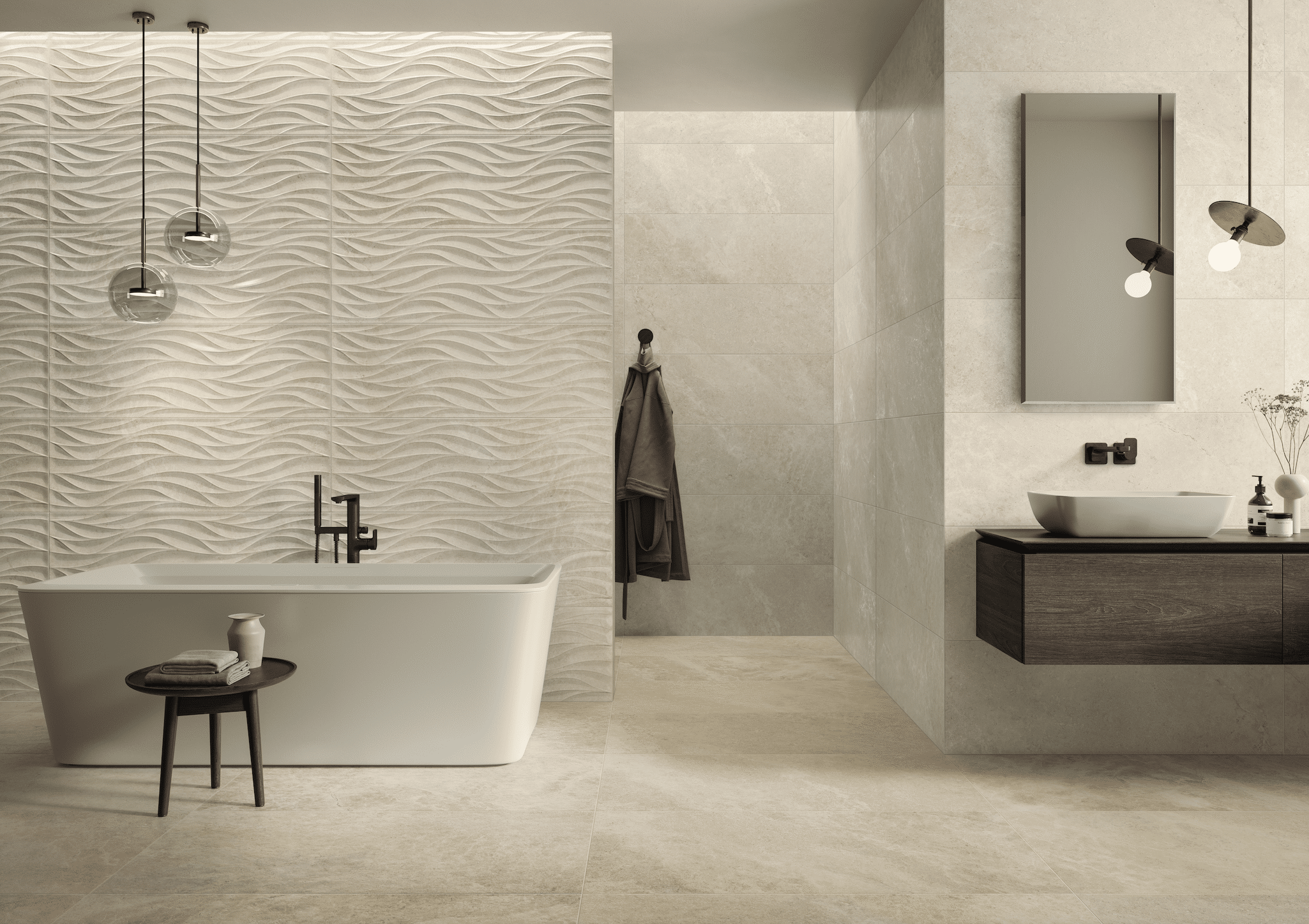 C. Bergmann zeigt ein helles Badezimmer mit gefliester Wand und gemusterten Fliesen, eine freistehende Badewanne und Hängelampen aus Glas von Villeroy & Boch.