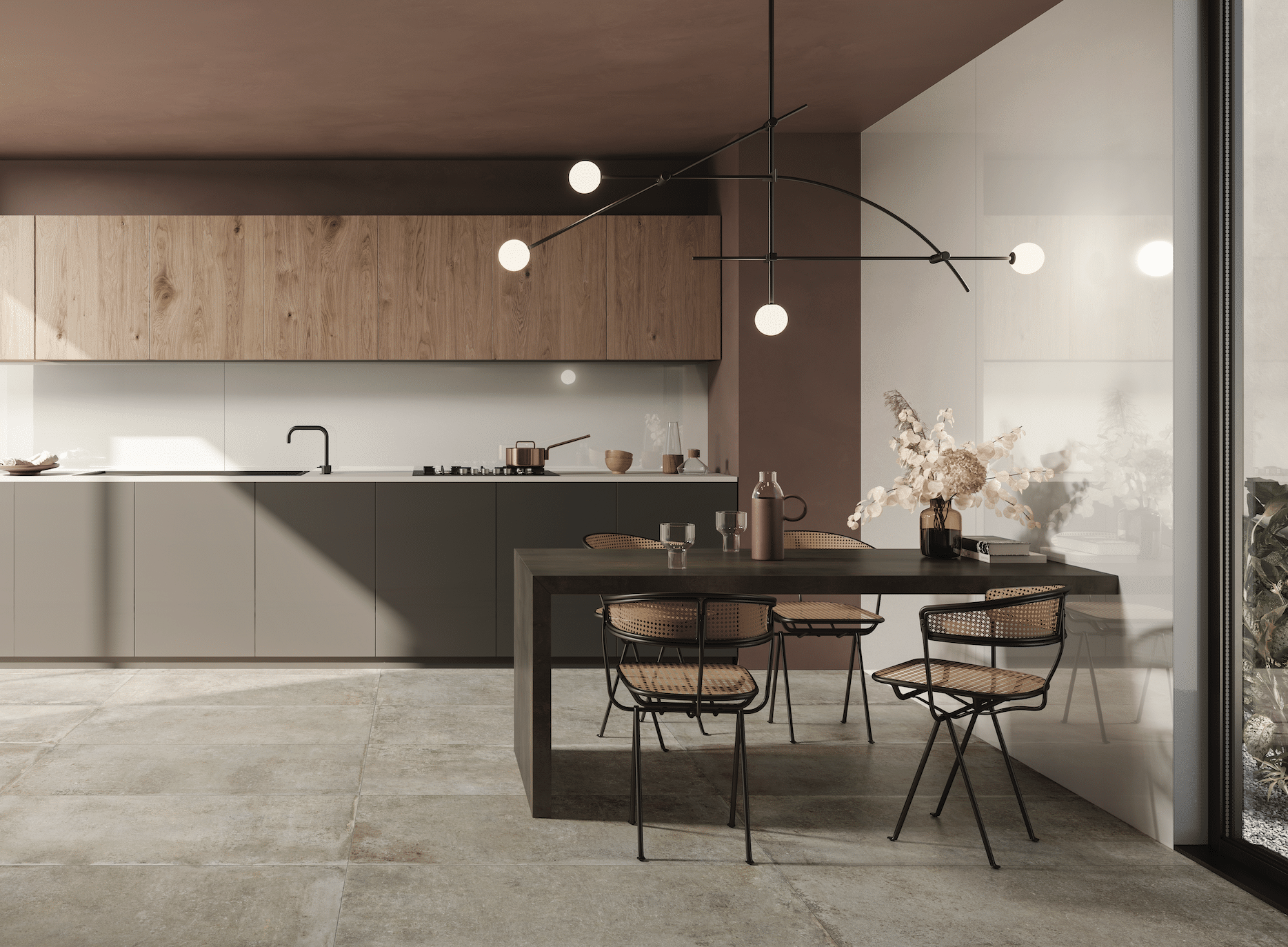 C. Bergmann zeigt eine Küche mit grauer Küchenzeile, einen Hängeschrank aus Holz an der Wand und mit einem dunklen Esstisch, Stühlen aus Materialmix und einer modernen Hängelampe von Flaviker.