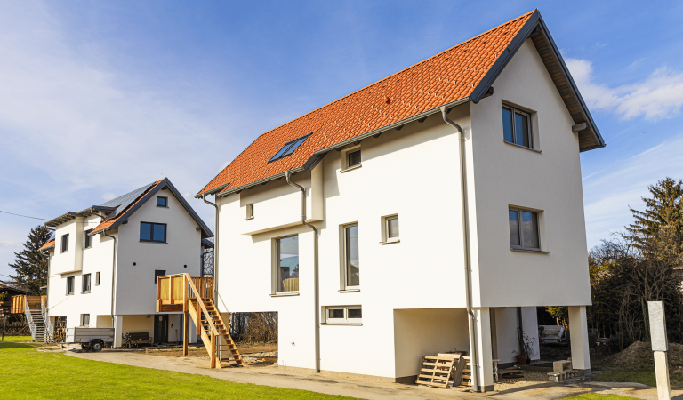 Einfamilienhaus mit Satteldach, Aussentreppe aus Holz und überdachtem Hauseingang von DIALOG Haus.