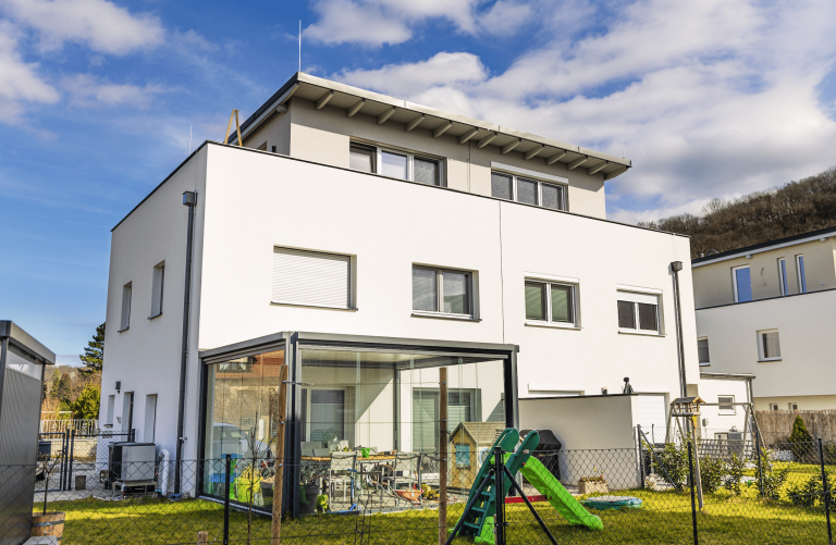 Mehrstöckiges Einfamilienhaus mit Flachdach, Balkon und Dachterrasse von DIALOG Haus.