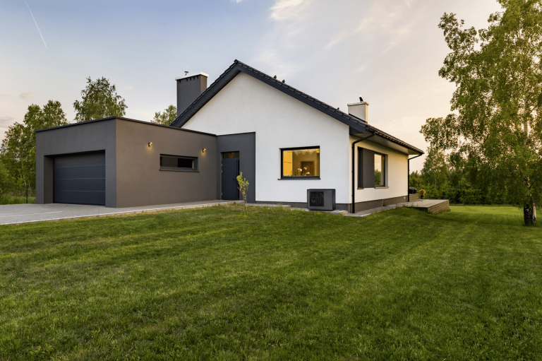 Dunkelgraue Wärmepumpen-Außeneinheit an der Hauswand eines Wohnhauses von Dimplex.