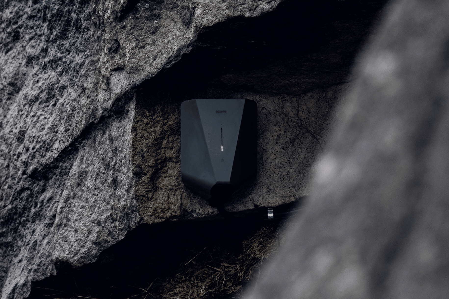 easee zeigt eine elegante, schwarze Wallbox die an einer Steinwand montiert wurde.