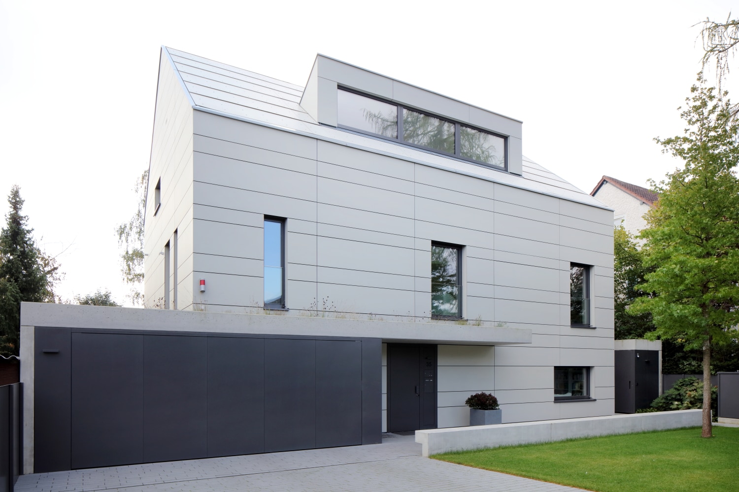 ETIVR zeigt ein modernes Einfamilienhaus mit hellgrauen Fassadenplatten von EQUITONE.