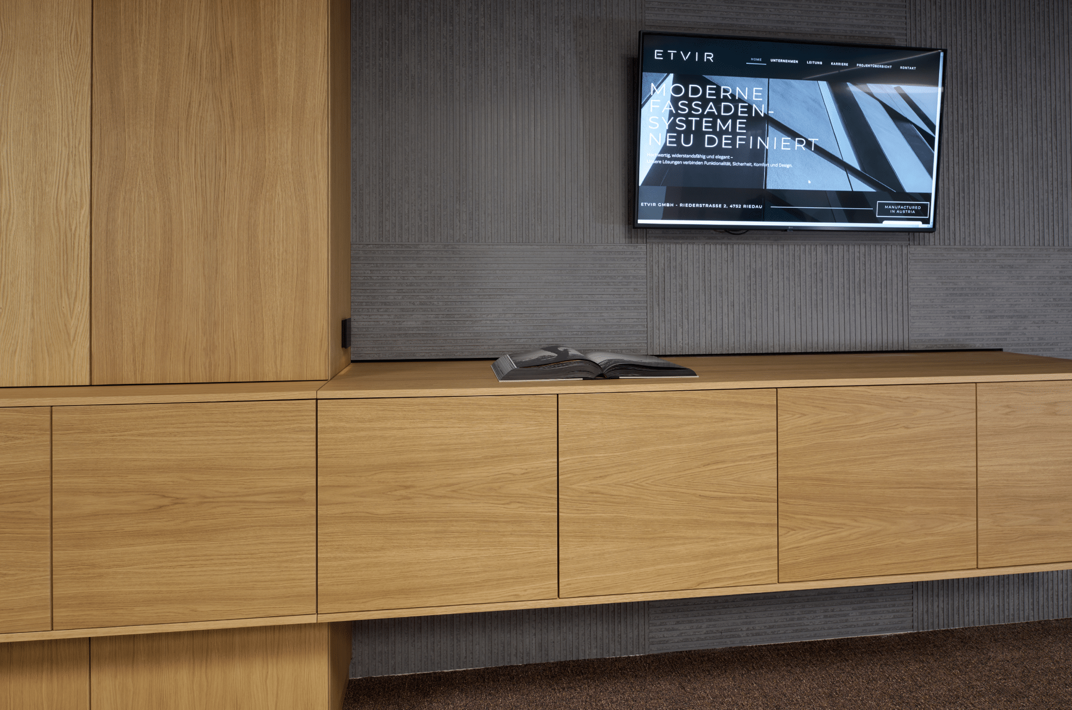 ETVIR zeigt ein Büro mit Betonwand, Fernseher und Wandverbau aus Holz. © raumpixel