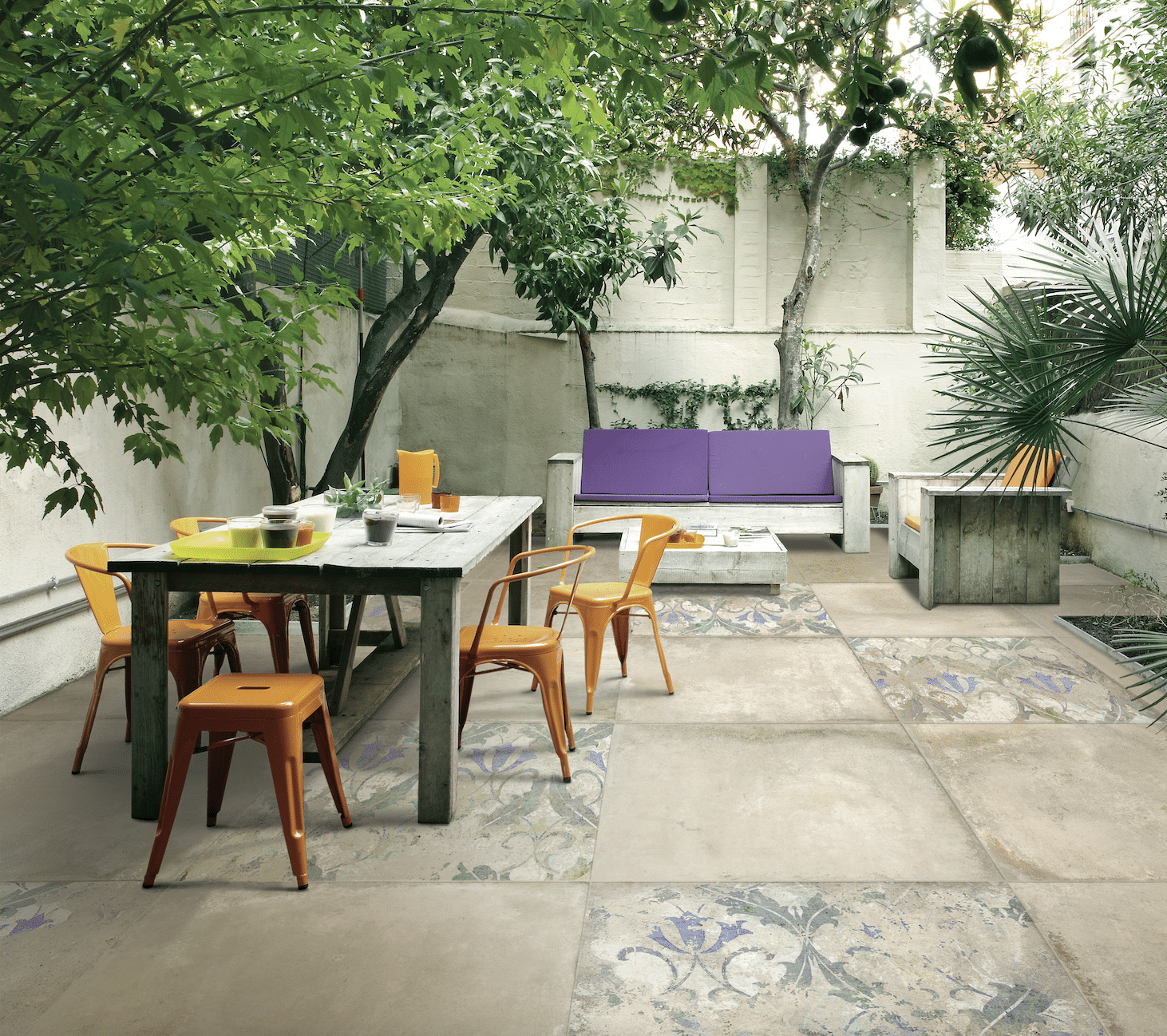 Terrasse mit Essbereich, Sitzmöglichkeiten und teilweise gemustertem Fliesenboden im portugiesischen Azulejo-Stil.