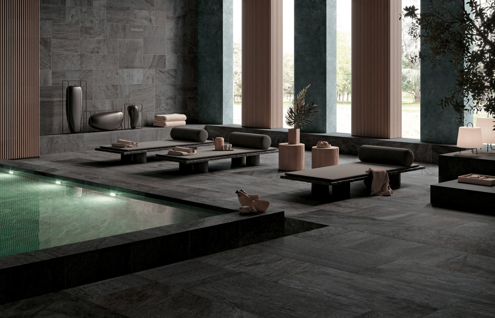 Felbermair zeigt ein elegantes indoor Swimmingpool mit dunklen Wand- und Bodenfliesen von Mirage.
