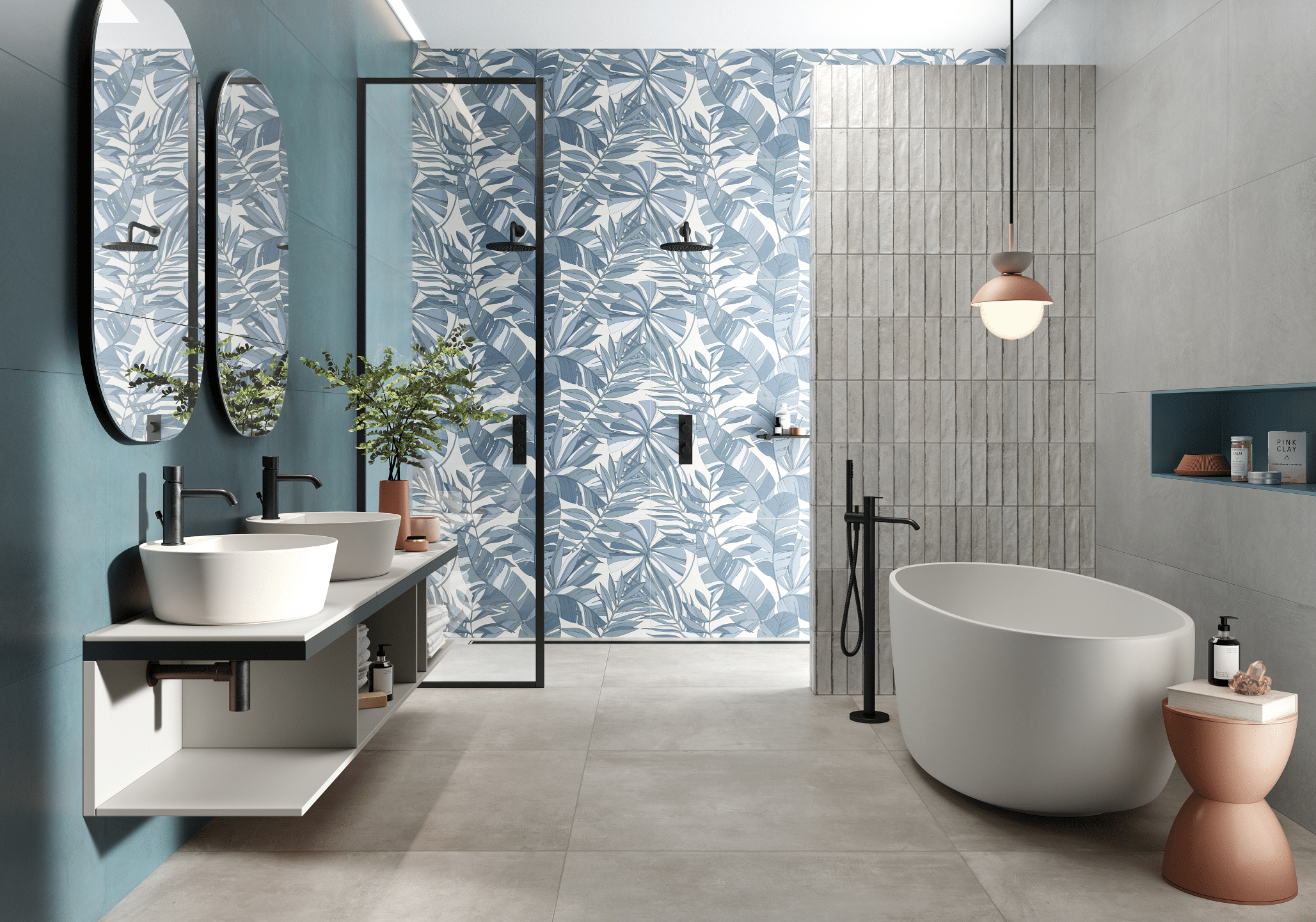 Fliesendorf zeigt ein Badezimmer mit weißen Doppelwaschbecken, zwei ovalen Spiegeln an der Wand, Dusche mit blau gemusterter Wand.