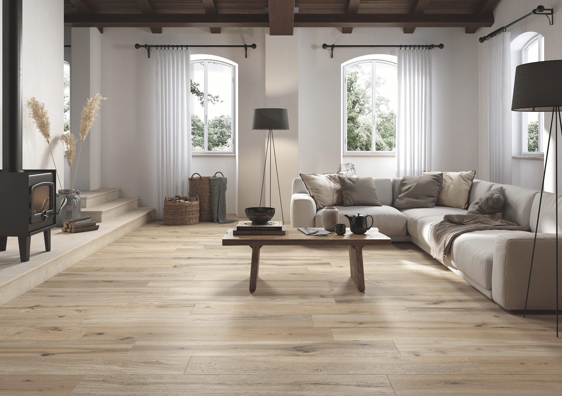 Fliesendorf zeigt ein Wohnzimmer in Naturtönen mit Holzboden und beiger Couchlandschaft mit einem schwarzen Kamin und gefliesten Treppen.