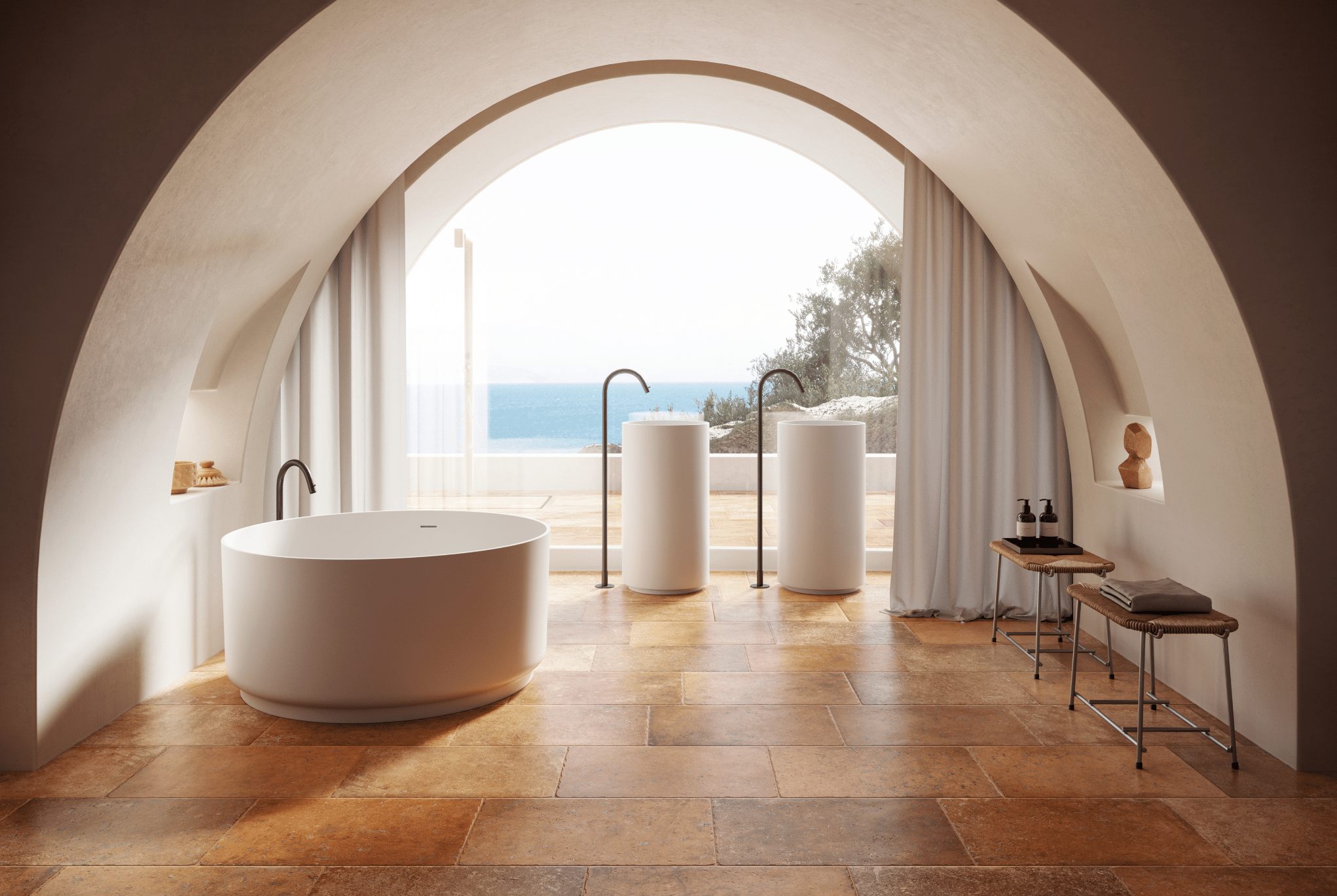Fliesendorf zeigt ein Badezimmer im mediterranen Stil und Fliesenboden in Terrakotta, einer freistehenden Badewanne und zwei Waschtischen vor einem großen Fenster mit Aussicht aufs Meer.