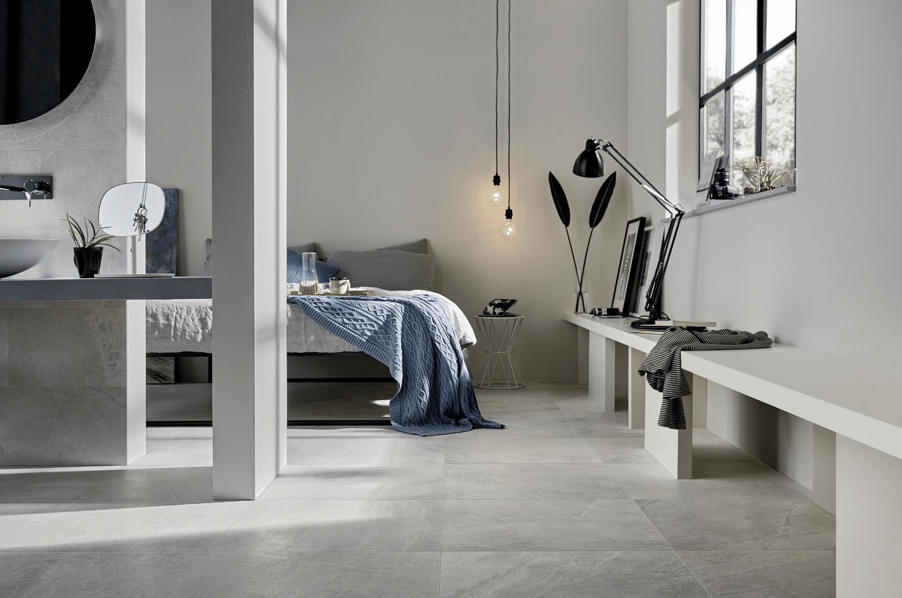 Fliesendorf präsentiert die hell marmorierten Fliesen am Boden eines Schlafzimmers mit Doppelbett inklusive Badezimmer.