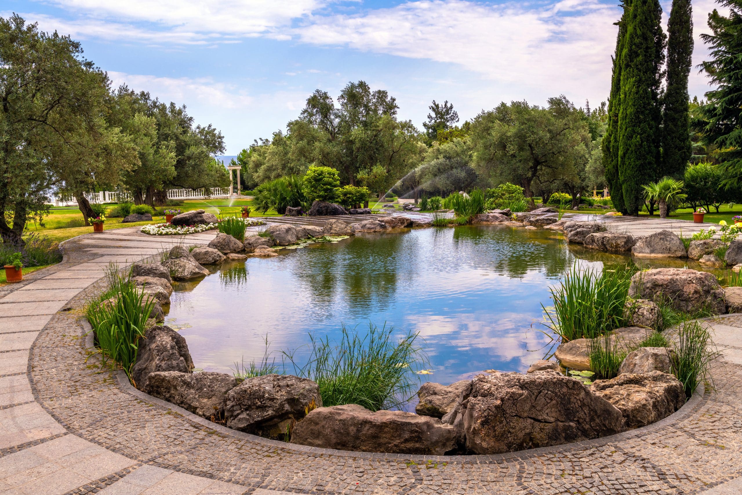 Gartenanlage mit schönem Teich und schönem Wegdesign.