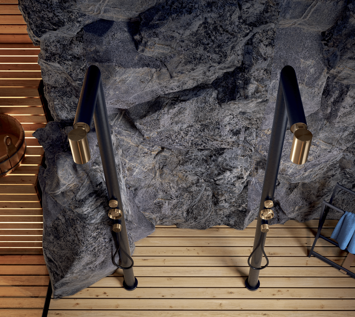 GESSI zeigt zwei Brausen in schwarz mit goldenen Akzenten in der Nahaufnahme vor einer Steinwand und Holzboden.