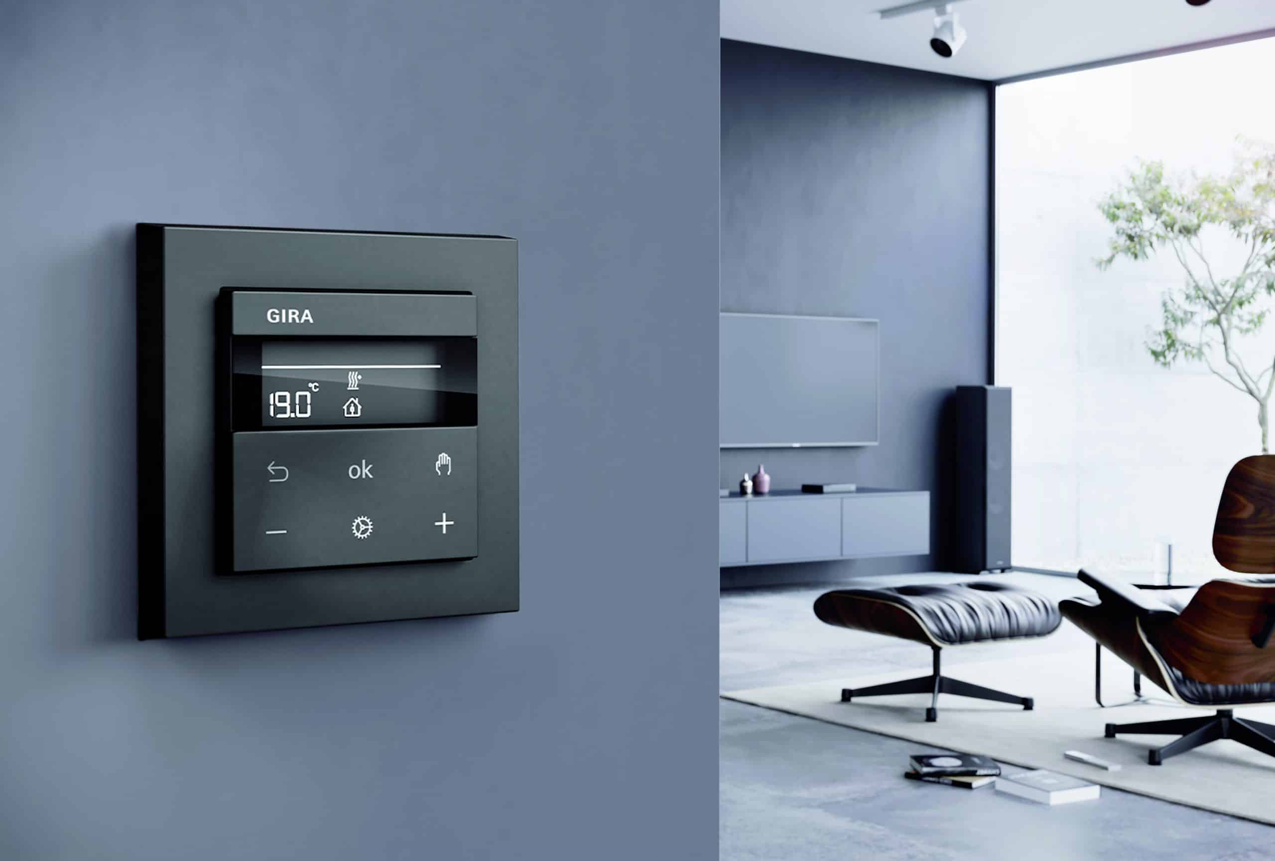 Gira zeigt ein Wohnzimmer mit formshöner Smart Home Temperaturregelung.