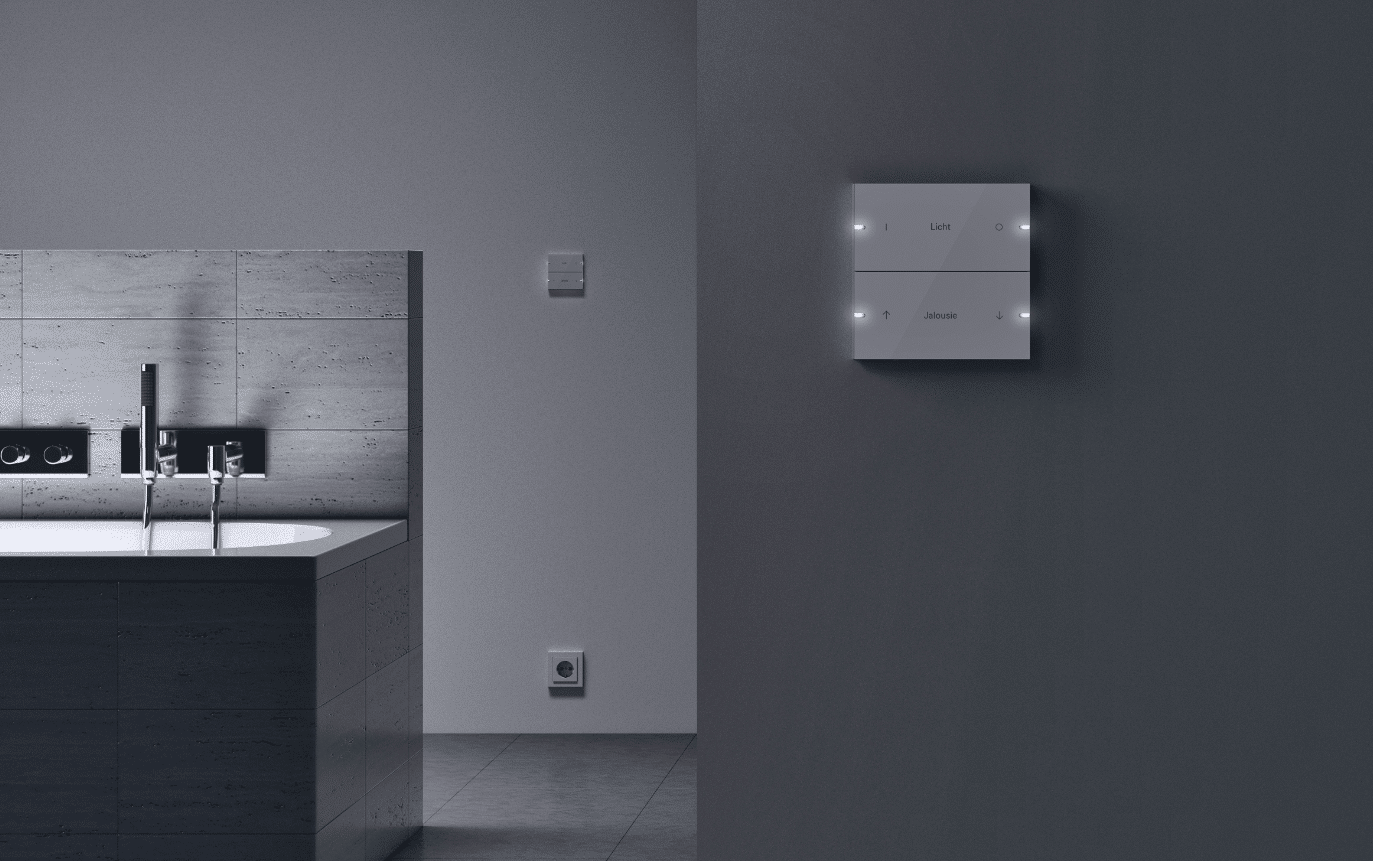 Gira zeigt ein dunkel gehaltenes Badezimmer mit smarter Lichtschalterlösung in weiß.