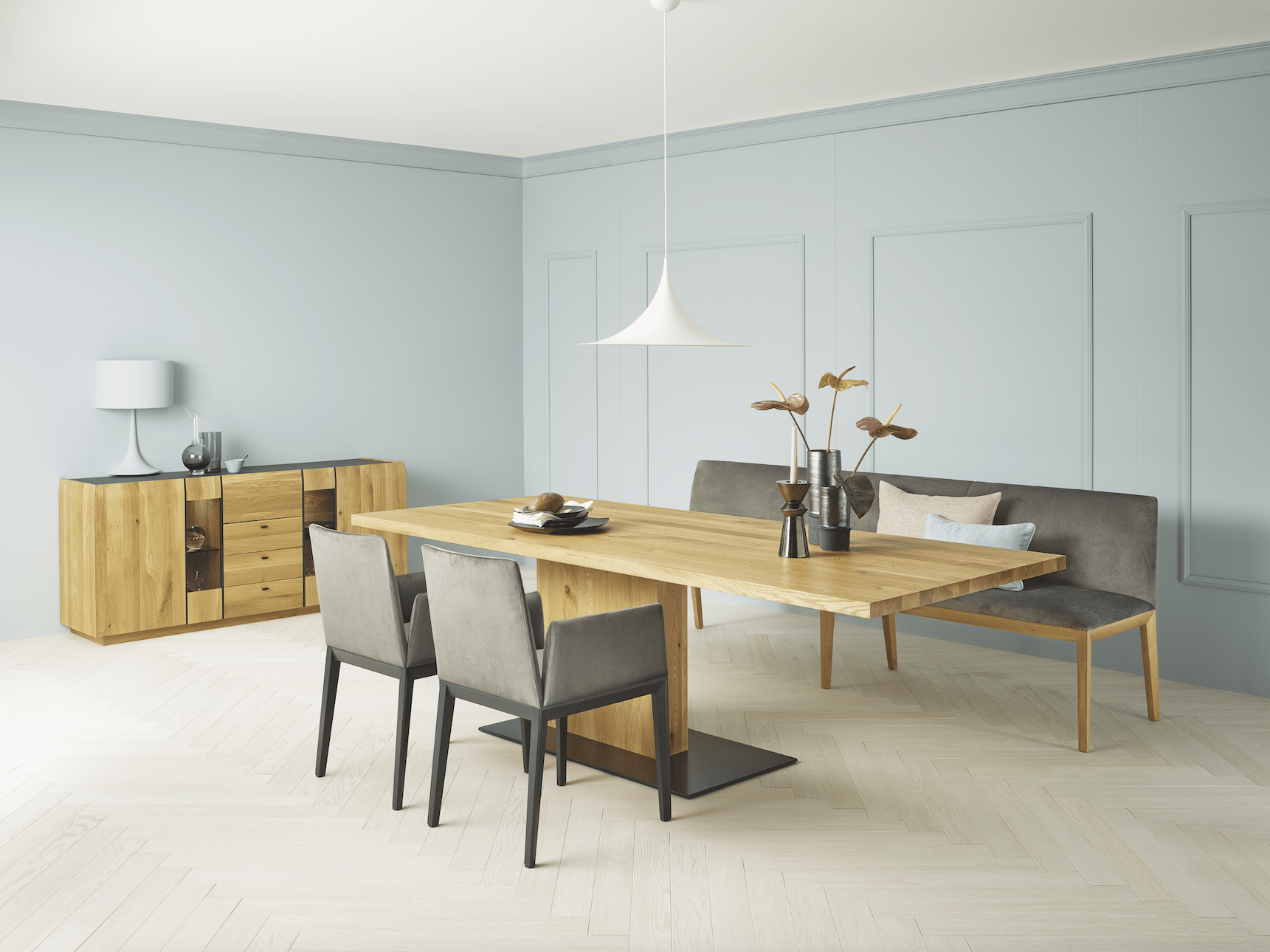 WOHNHAUS Grill & Ronacher zeigt ein Esszimmer mit Möbeln von ANREI in Asteiche gebürstet natur geölt und dunklen Stühlen.