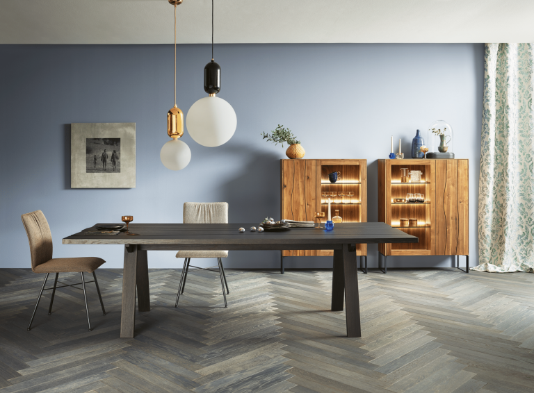 WOHNHAUS Grill & Ronacher zeigt eine moderne Essgruppe von ANREI, bestehend aus einem Esstisch aus dem Holz der Astnuss sowie Sideboards aus dem Holz der Asteiche sowie Stühle mit Stoffbezug.