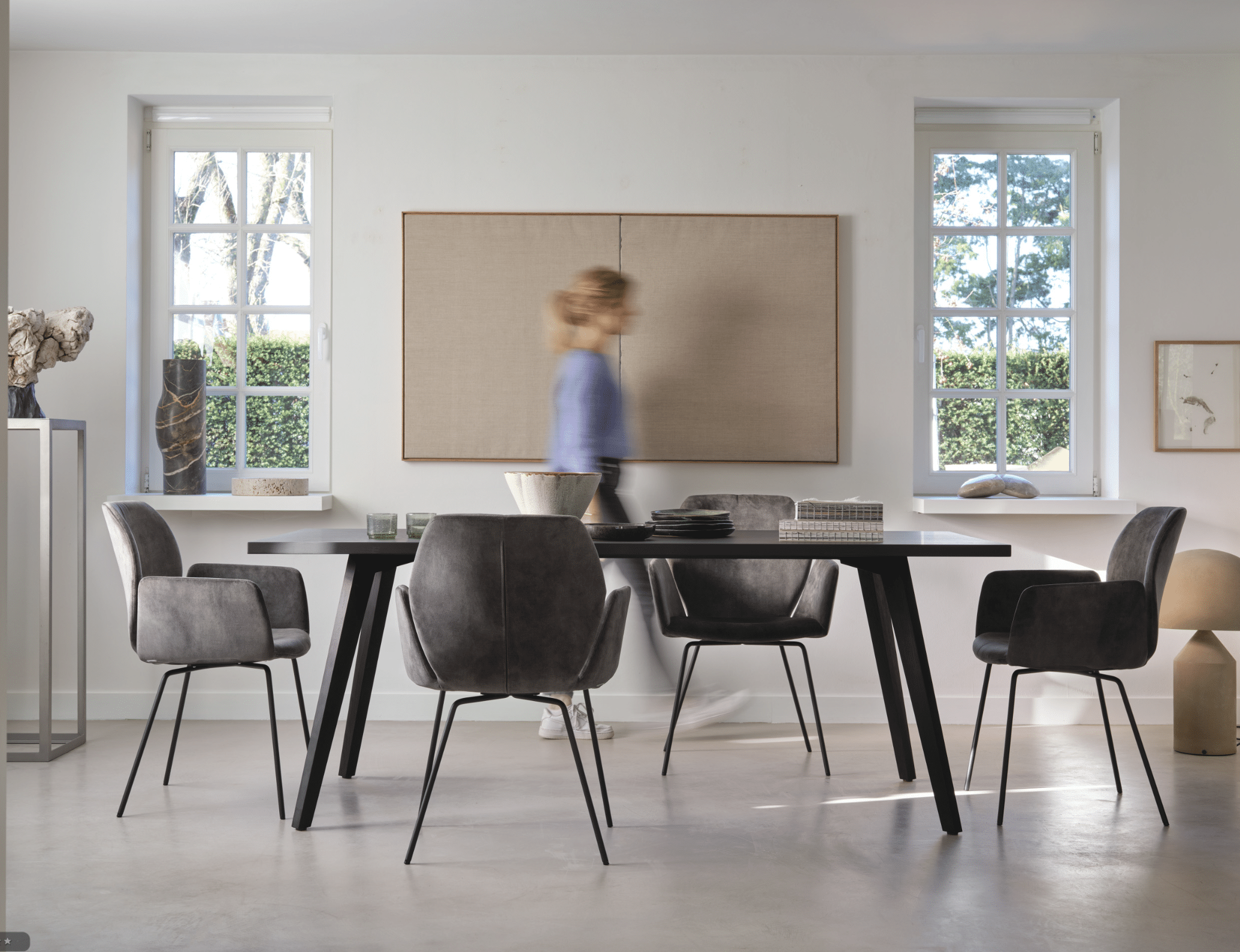 WOHNHAUS Grill & Ronacher zeigt eine Essgruppe von Mobitec Systems, bestehend aus einem Esstisch aus dunklem Holz und Stühlen mit Stoffbezug und schwarzen Metallfüßen.