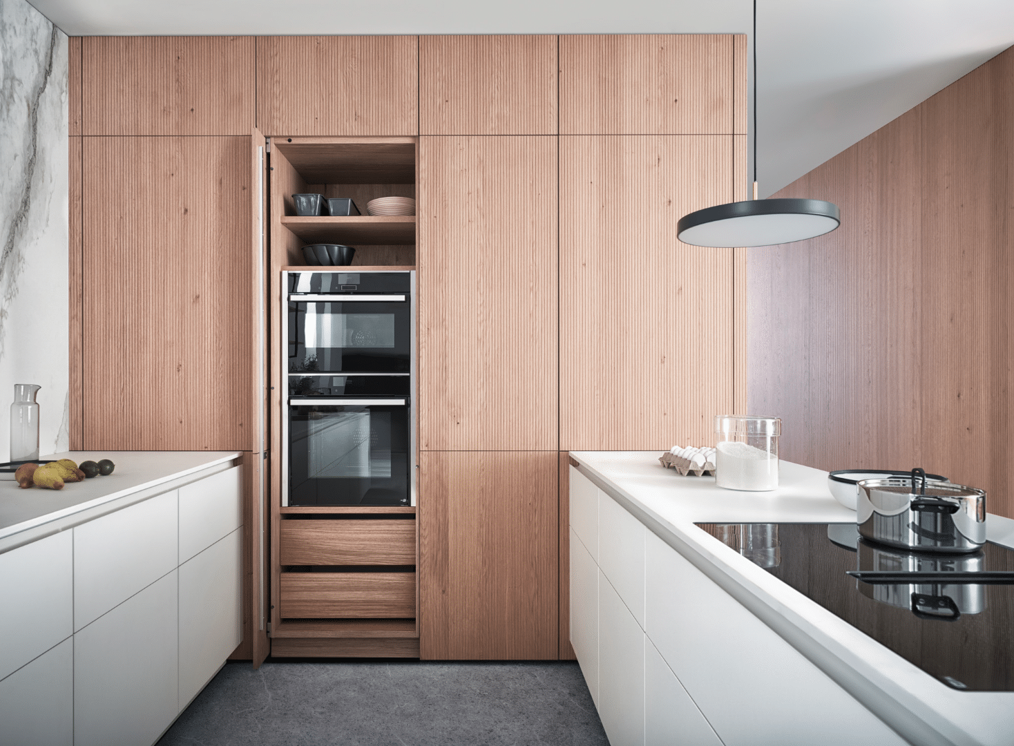 WOHNHAUS Grill & Ronacher zeigt eine moderne Inselküche von LEICHT Küchen mit praktischen, deckenhohen Schränken in hellem Holz.