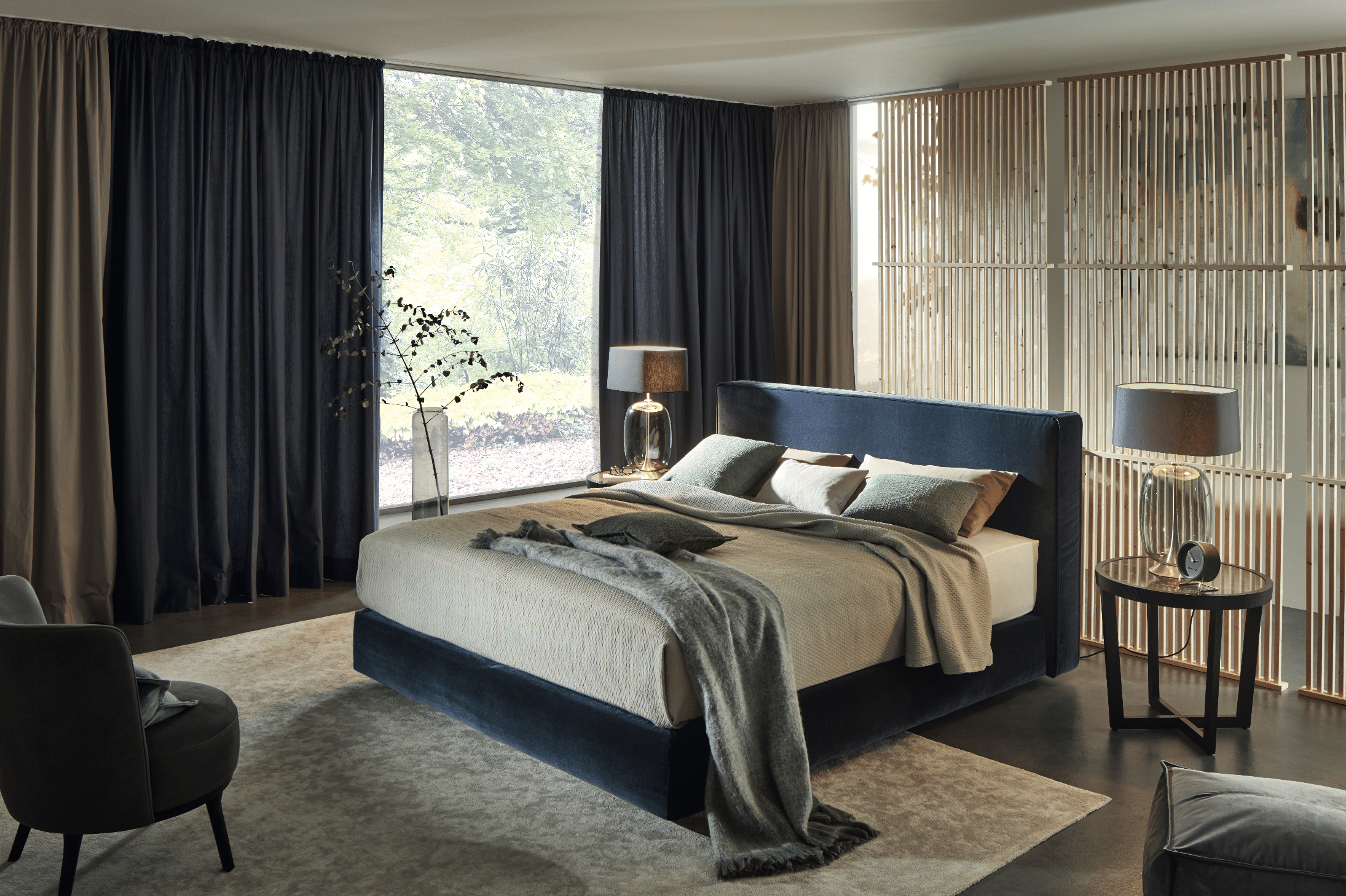 Grill & Ronacher zeigt ein Schlafzimmer mit sehr hohem Doppelbett in blau, blickdichten hohen Vorhängen und runden Nachttischen von Bielefelder Werkstätten.