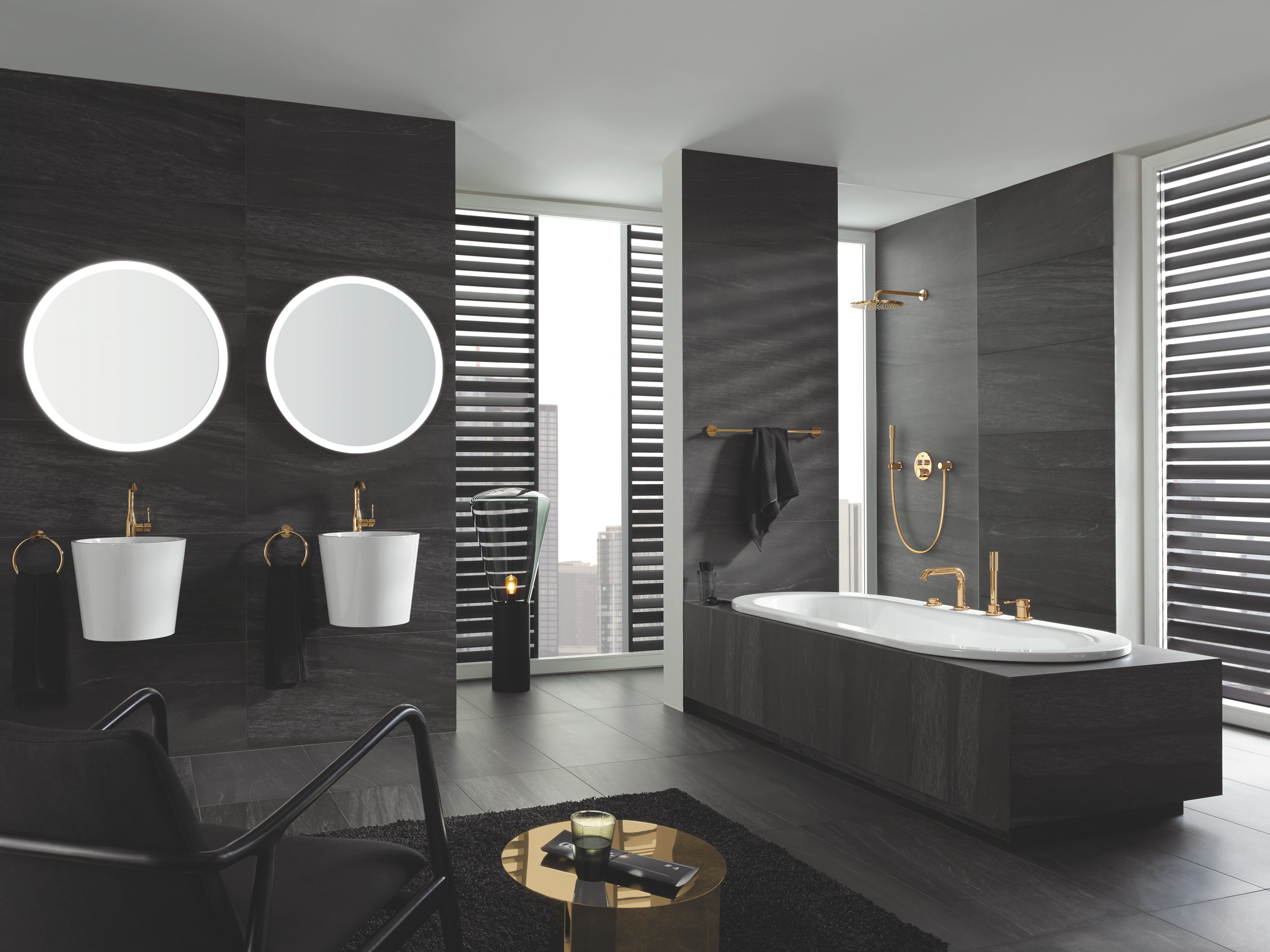 Grohe zeigt ein Badezimmer mit Waschbecken mit goldenen Essence Armaturen, Essencial Accessoires, sowie der Badewannen-4-Loch-Armatur Smart Control  und einer Rainshower Cosmopolitan Dusche.