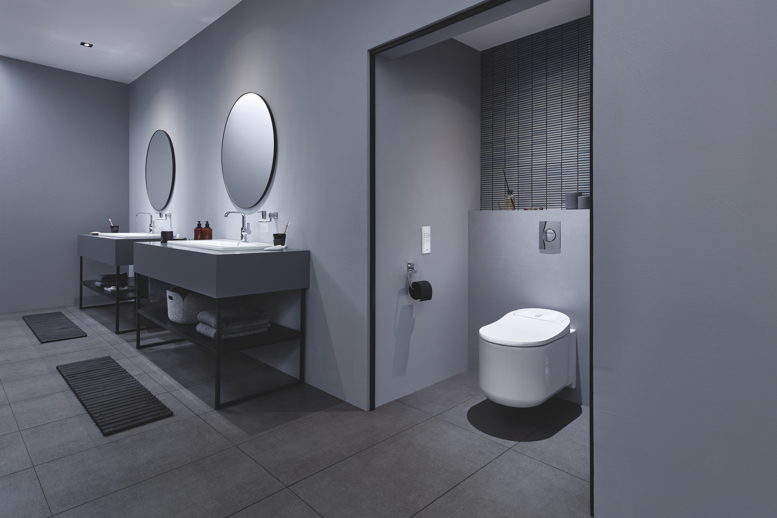 Grohe zeigt ein Badezimmer mit zwei Waschtischen mit Allure Armaturen, sowie Dusch-WC Sensia Arena mit Betätigungsplatte Nova Cosmopolitan.