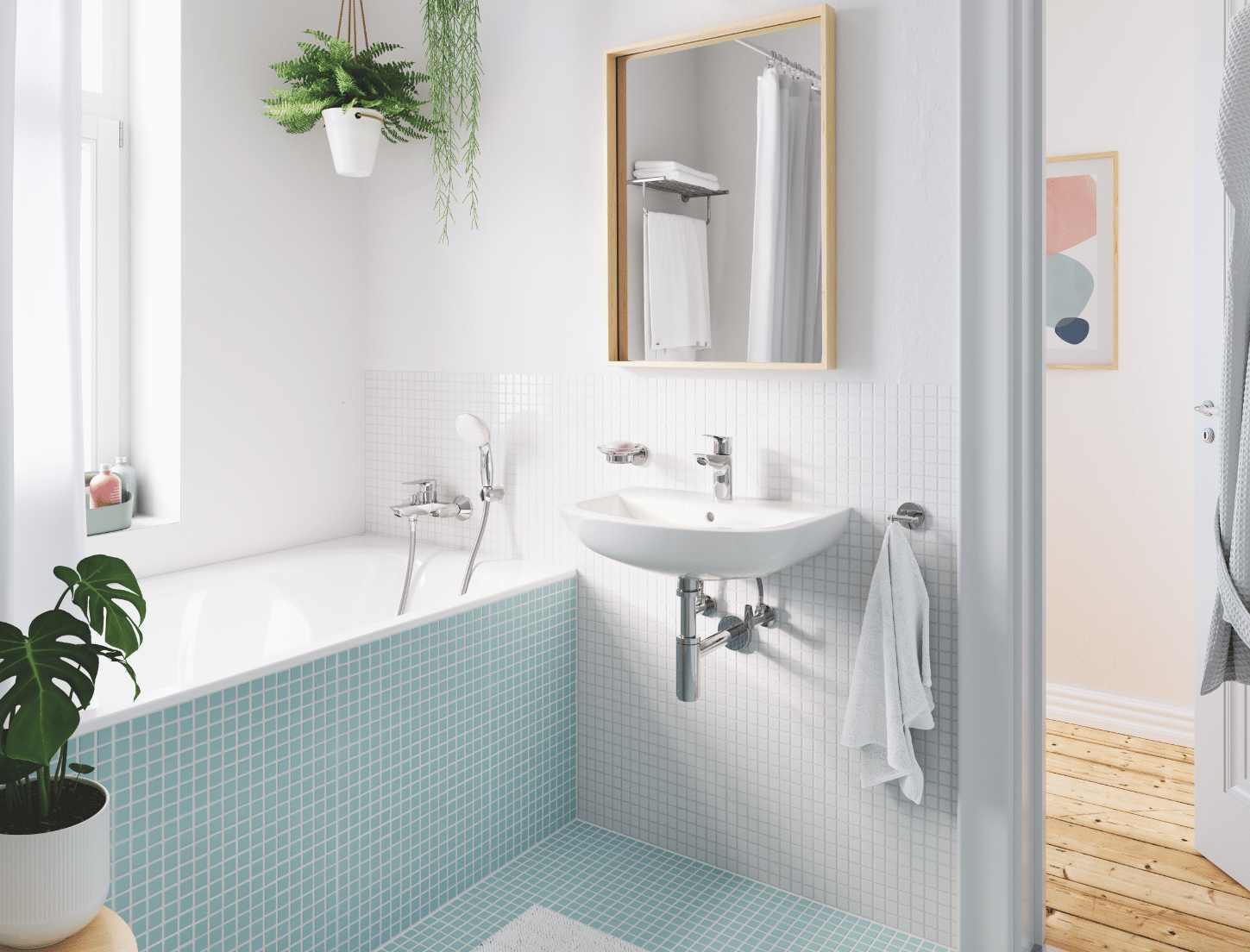 Grohe zeigt ein Badezimmer mit kleinen blauen Fliesen einem Waschbecken mit Spiegel und einer Badewanne.
