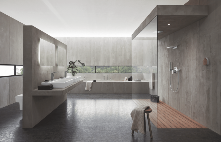 Grohe zeigt ein hellgraues Bad mit Walk-In Dusche, einer Glasduschwand, und zwei Waschbecken.