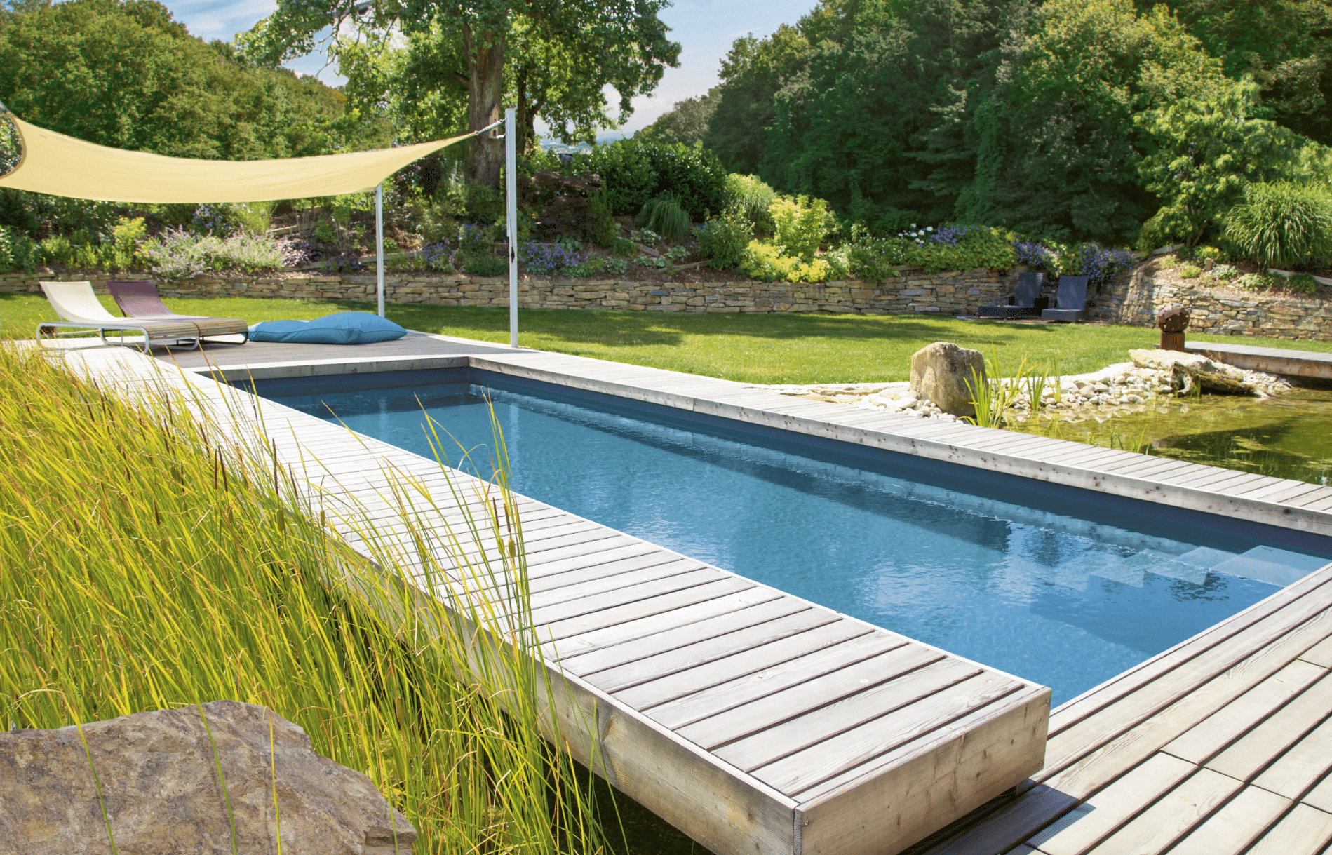 Garten mit Pool, Holzsteg und Sonnensegel, angelegt von Gartengestalter Hablesreiter.