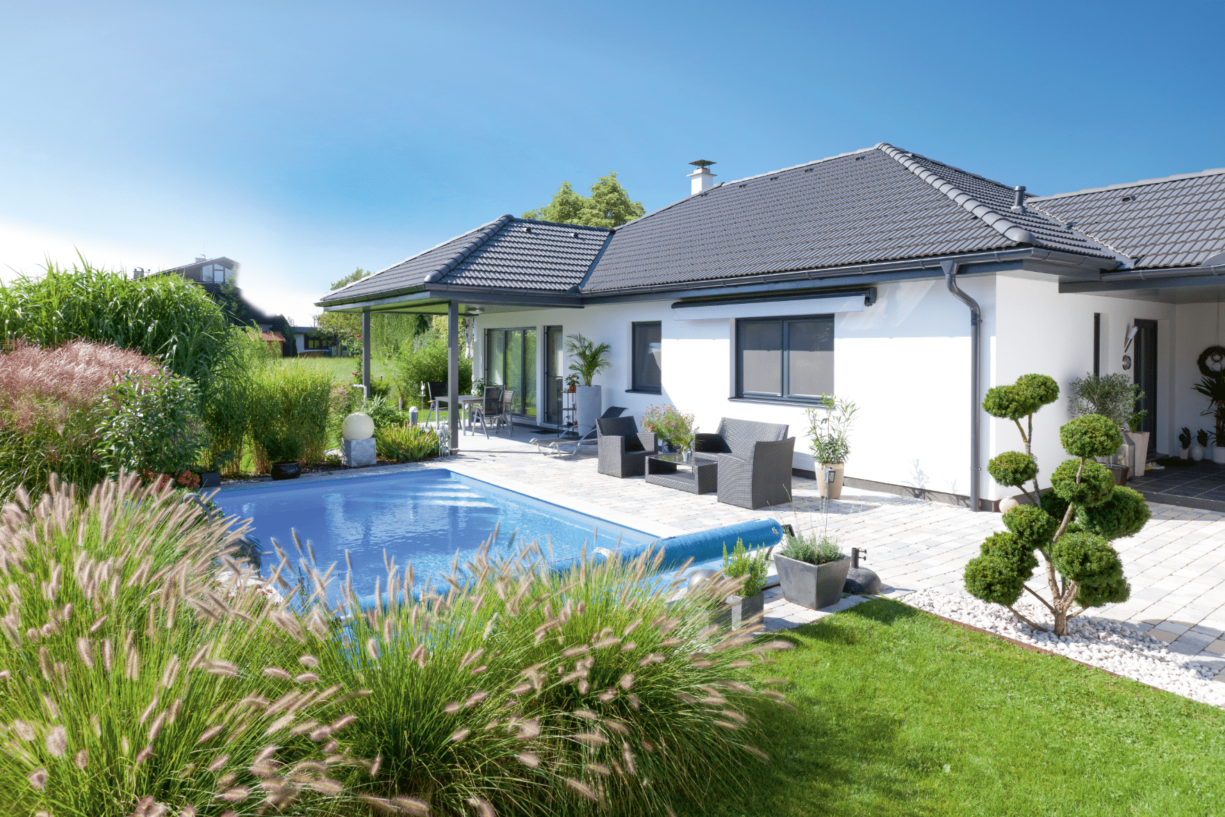 Bungalow-Fertigteilhaus mit Terrasse und Pool von Hartl Haus.