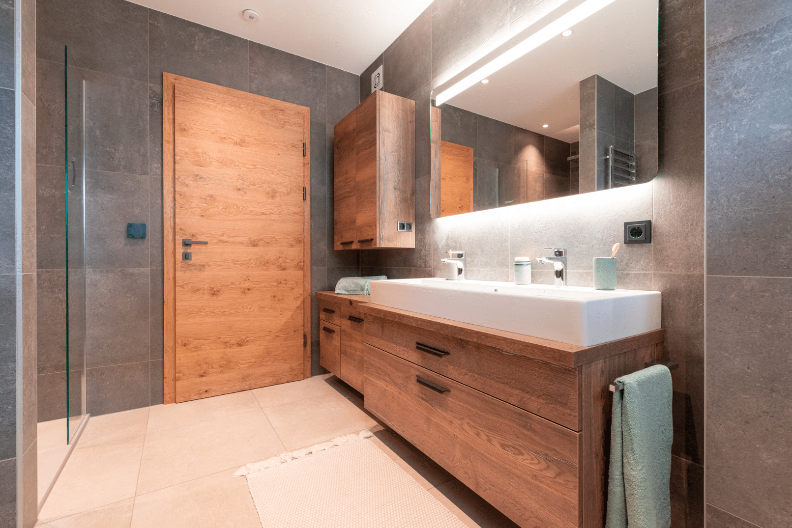 Hartl Haus zeigt ein Badezimmer mit aufeinander abgestimmter Holztür und Kästen.