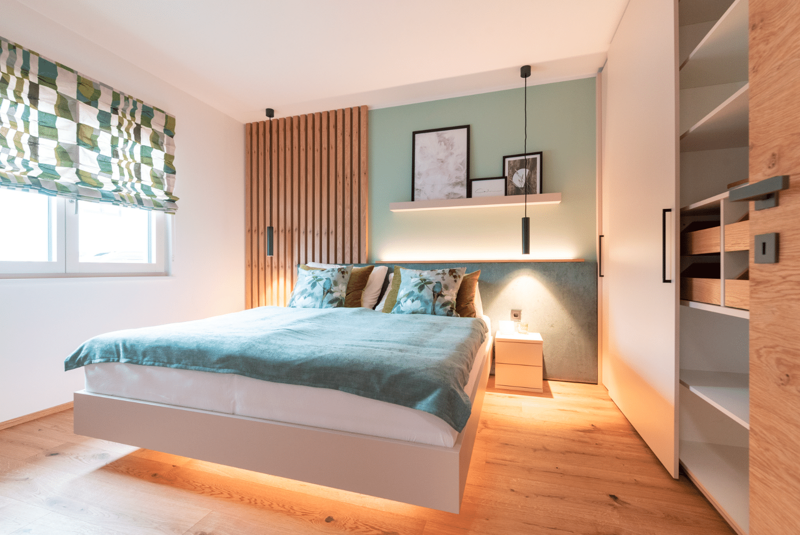 Hartl Haus zeigt ein Schlafzimmer mit Holzboden und Wandverkleidung aus Holz sowie großem Einbauschrank.