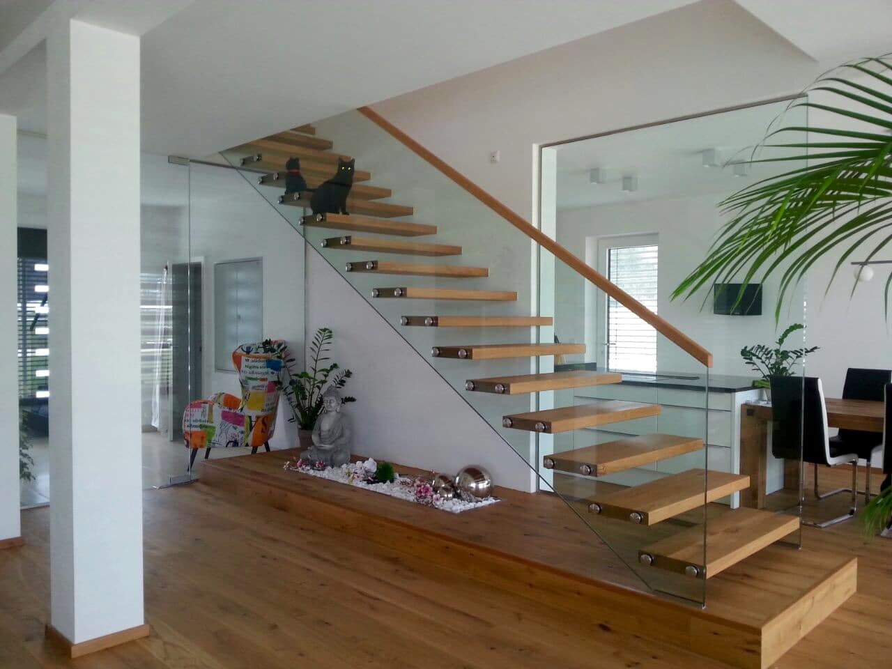 Wohnraum mit moderner Treppe von Hausjell, Purrer & Stockinger aus Holz und Glas.