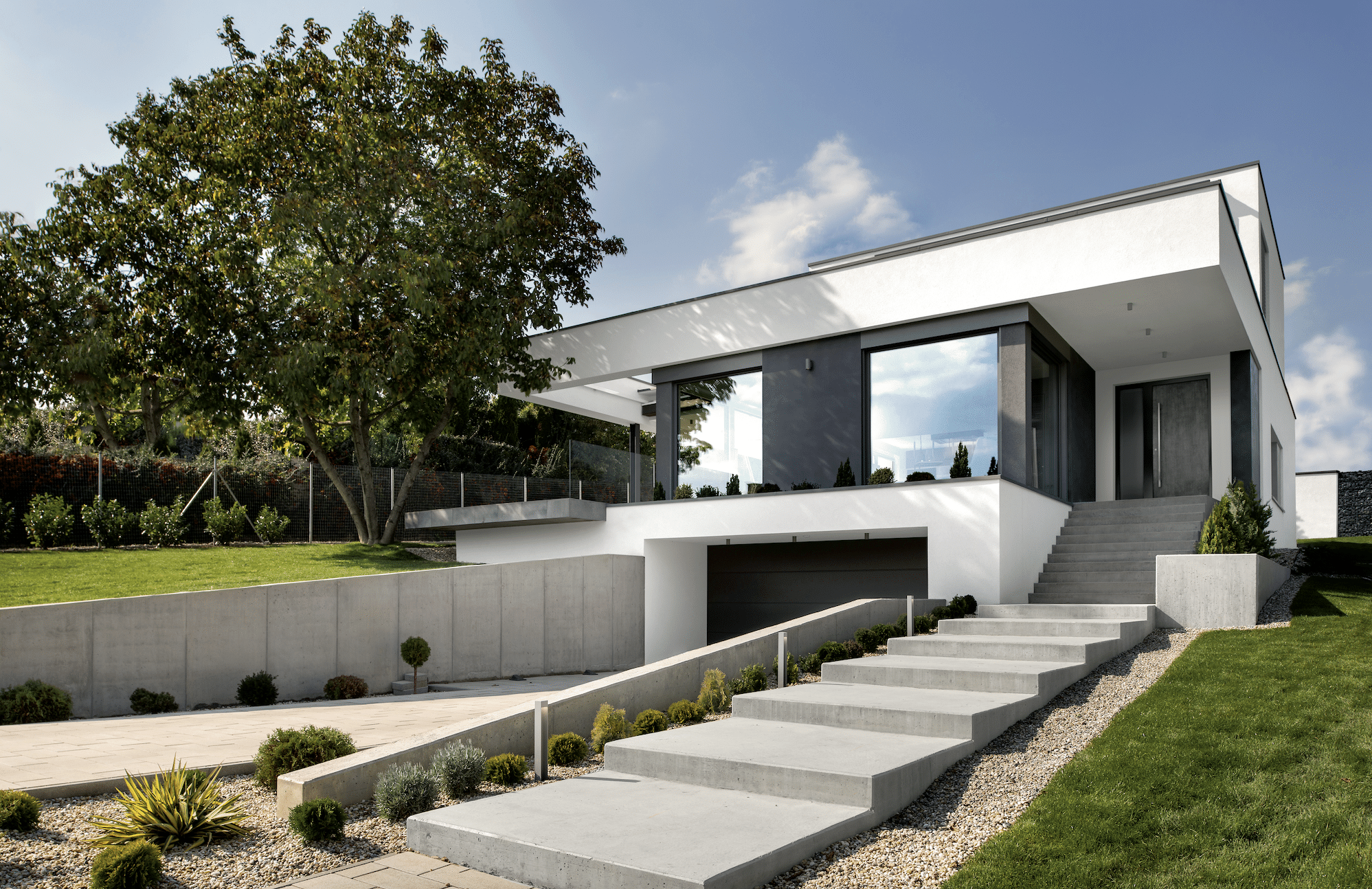 Internorm präsentiert ein modernes Wohnhaus mit Ganzglassystem, Flachdach und einer praktischen Garage.