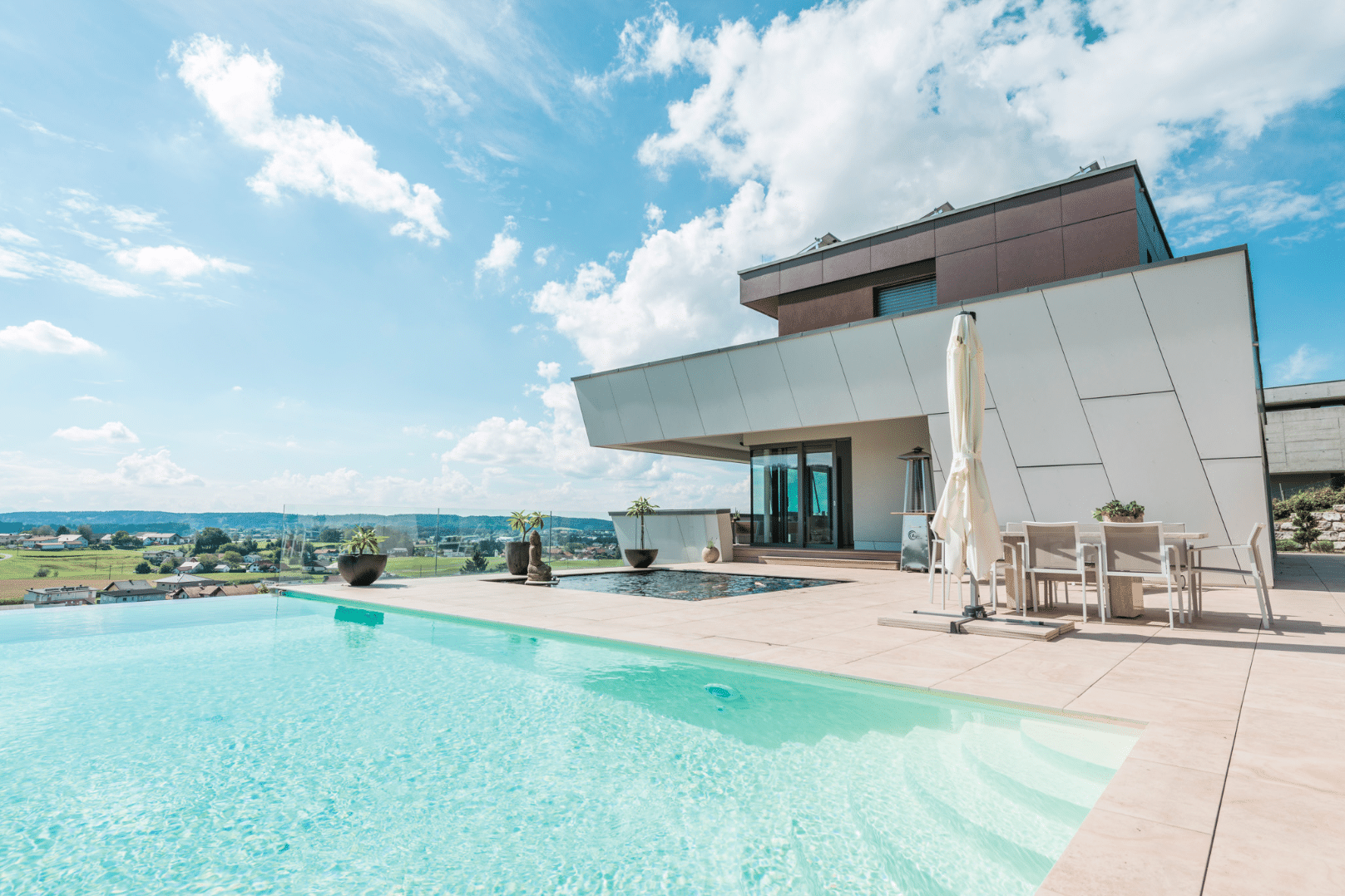 Internorm zeigt ein Architektenhaus mit außergewöhnlicher Gebäudeform in Hanglage mit großer Terrasse mit Pool und Teich.
