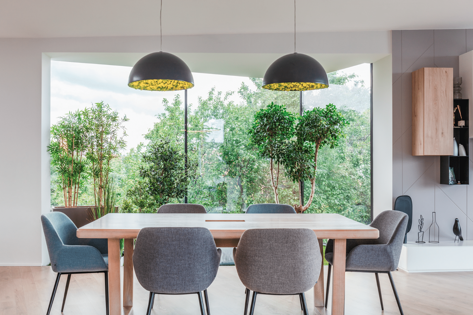 Internorm zeigt ein Esszimmer mit schönem Blick in den grünen Garten, Dank hohen Glaselementen in Form eines modern interpretierten Erkers.