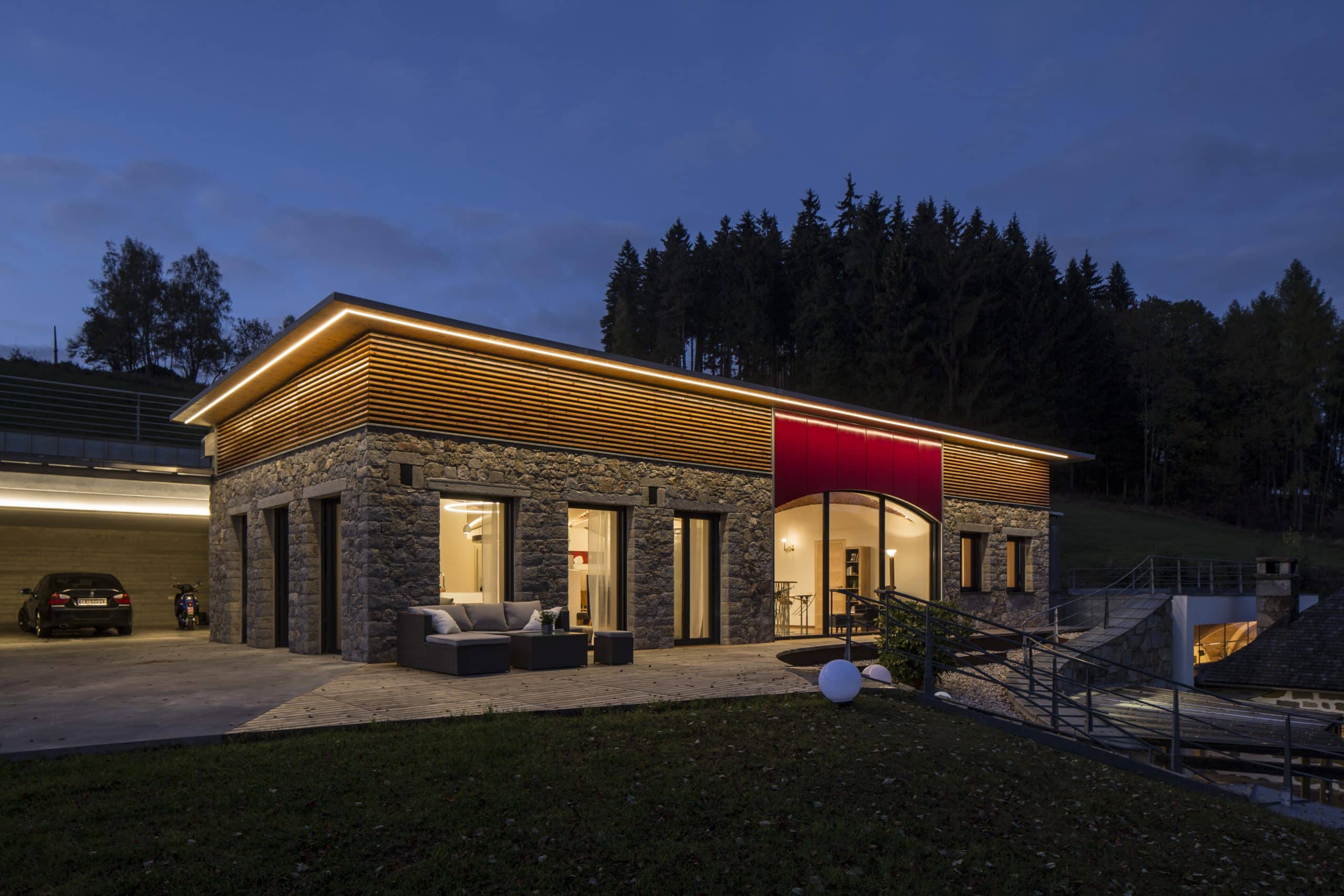 Flachdachhaus mit Natursteinfassade bei Nacht von Jahn Gewölbebau.