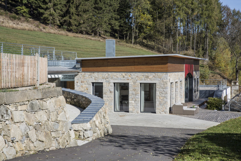 Flachdachhaus mit Natursteinfassade und bodentiefen Verglasung von Jahn Gewölbebau.