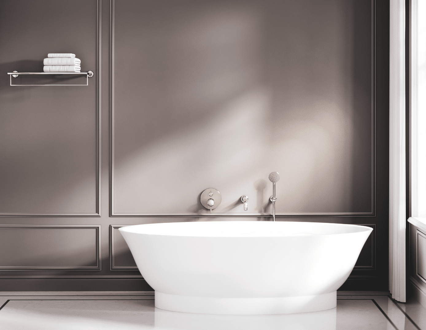 Jörger zeigt eine weisse freistehende Badewanne, Armaturen in Silbernickel und einem an der grauen Wand montierten Handtuchhalter mit weissen Handtüchern.