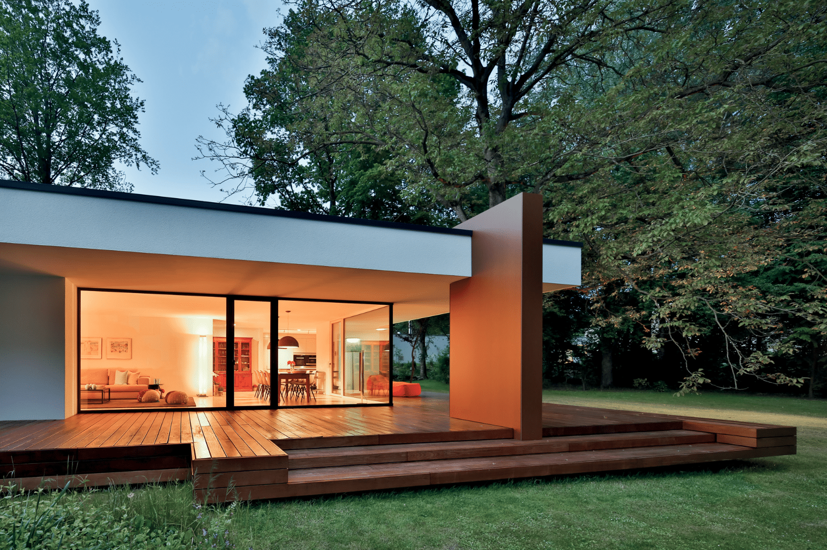 Bungalow mit Flachdach, teilüberdachter Terrasse und deckenhohen Fenstern sowie Terrassentür von Josko.