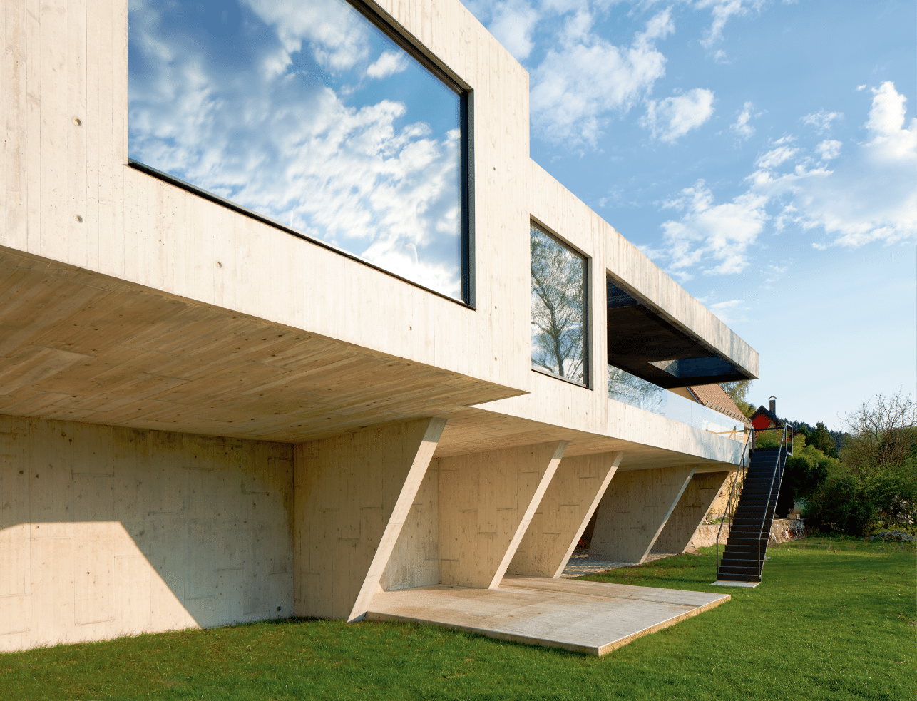 Futuristisches Architektenhaus in Betonoptik, mit großen Fenstern von Josko.